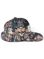 JAKE & IPI IBE Elenyor cap featuring a woodland camouflage pattern with a white embroidered logo on the front.
