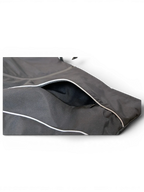 JAKE & IPI IBE Elenyor jacket featuring a black fabric exterior with reflective piping and a zippered pocket detail.