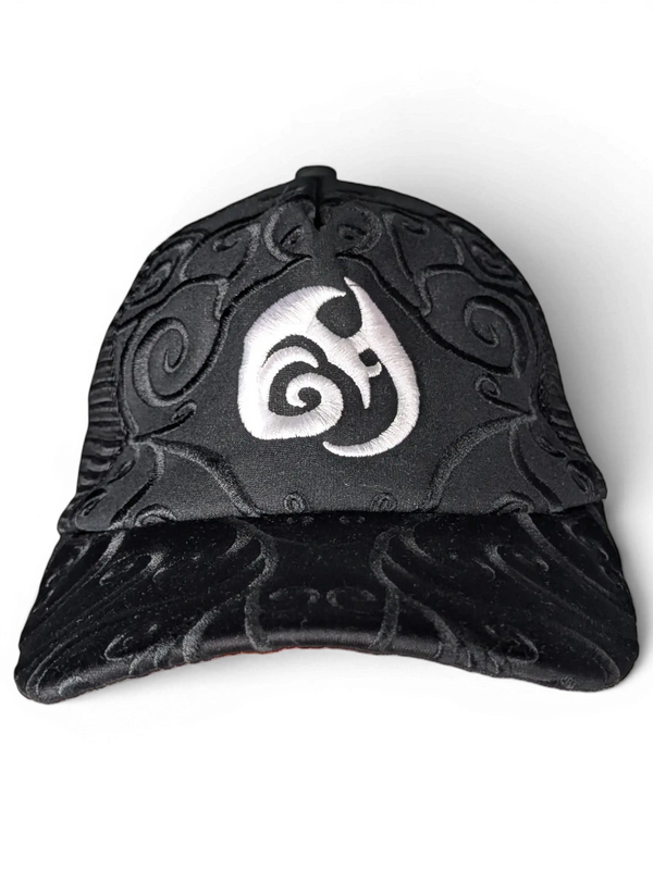 JAKE & IPI IBE Morivelle black cap with white embroidered logo and intricate tonal swirl patterns on the crown and brim.