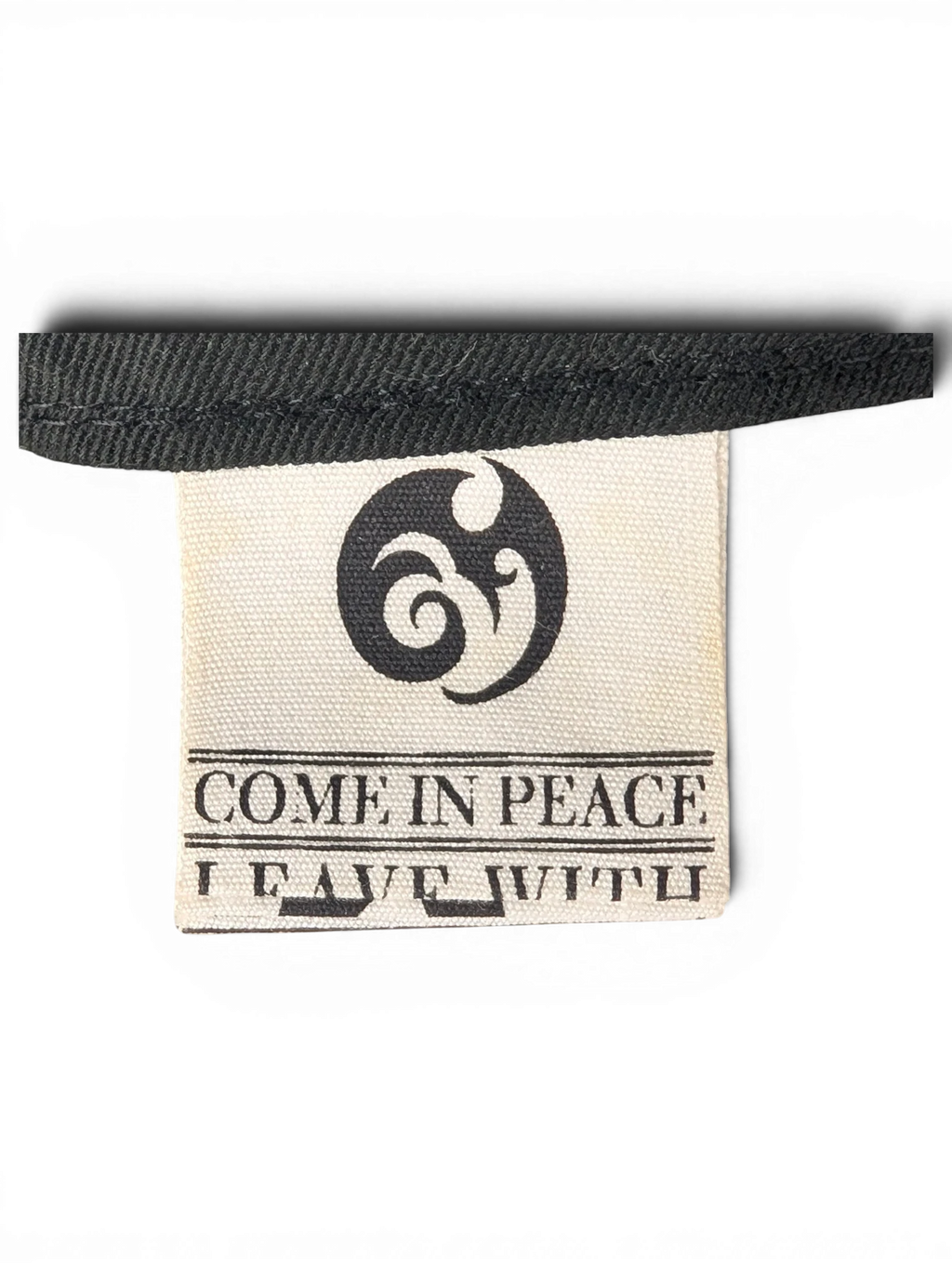 JAKE & IPI IBE Morivelle cap interior fabric label with Come In Peace branding and logo