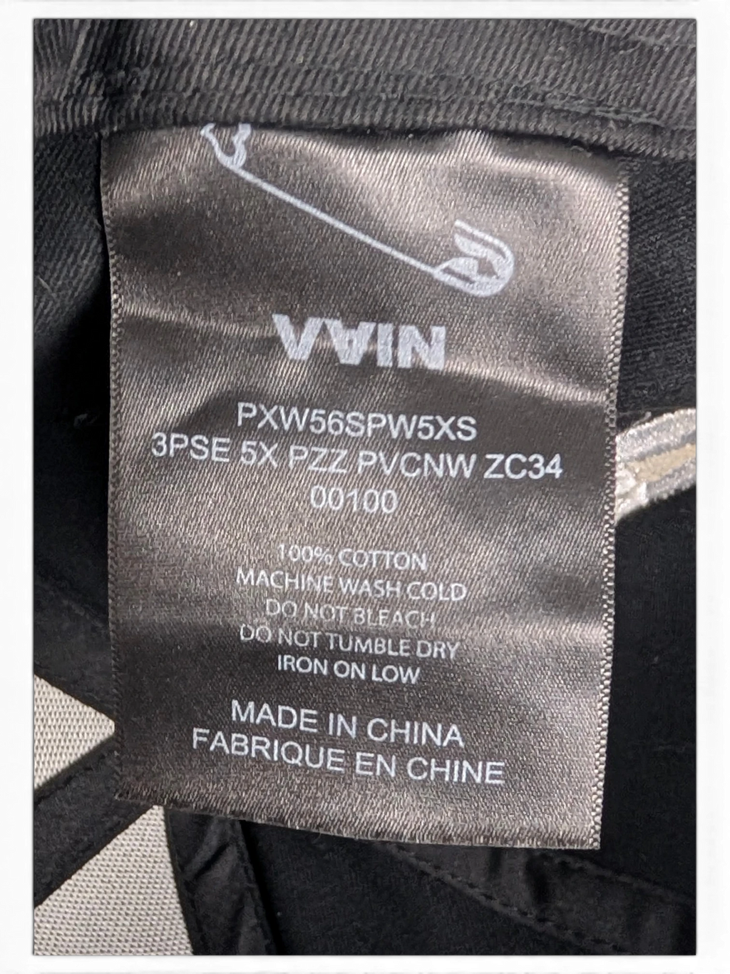 JAKE & IPI IBE Vain cap black cotton care label with safety pin logo and washing instructions