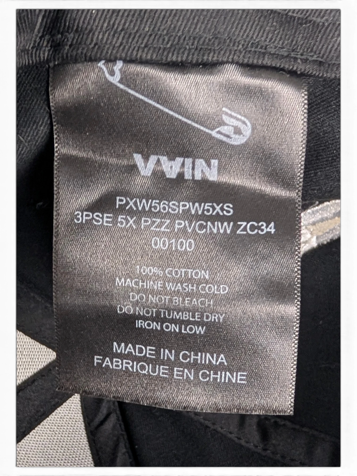 JAKE & IPI IBE Vain cap black cotton care label with safety pin logo and washing instructions