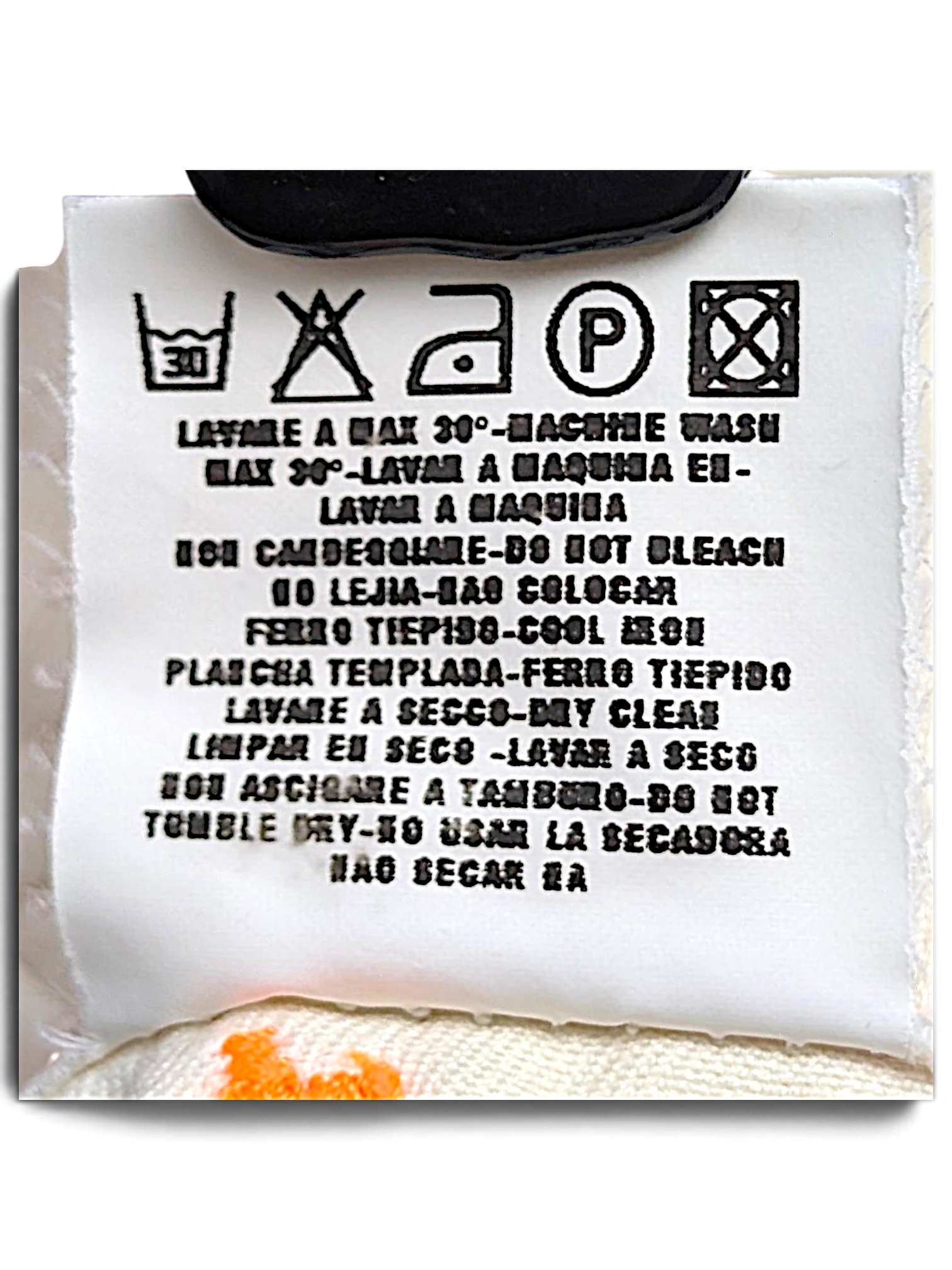 JAKE & IPI Indian Rose white cargo pants care label with washing instructions and orange contrast stitching detail