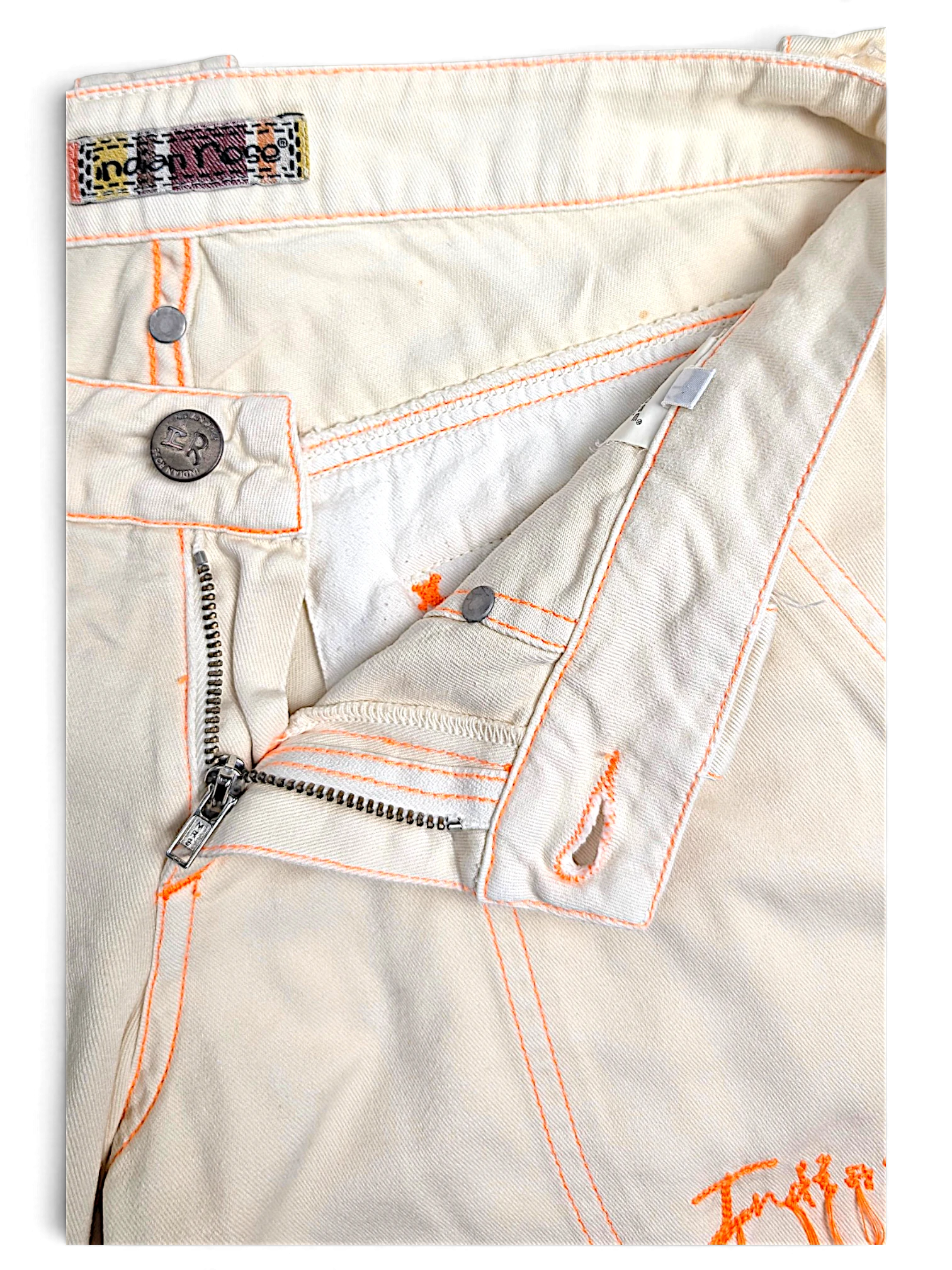 JAKE & IPI Indian Rose white cotton cargo pants with vibrant orange contrast stitching and branded metal button detail.