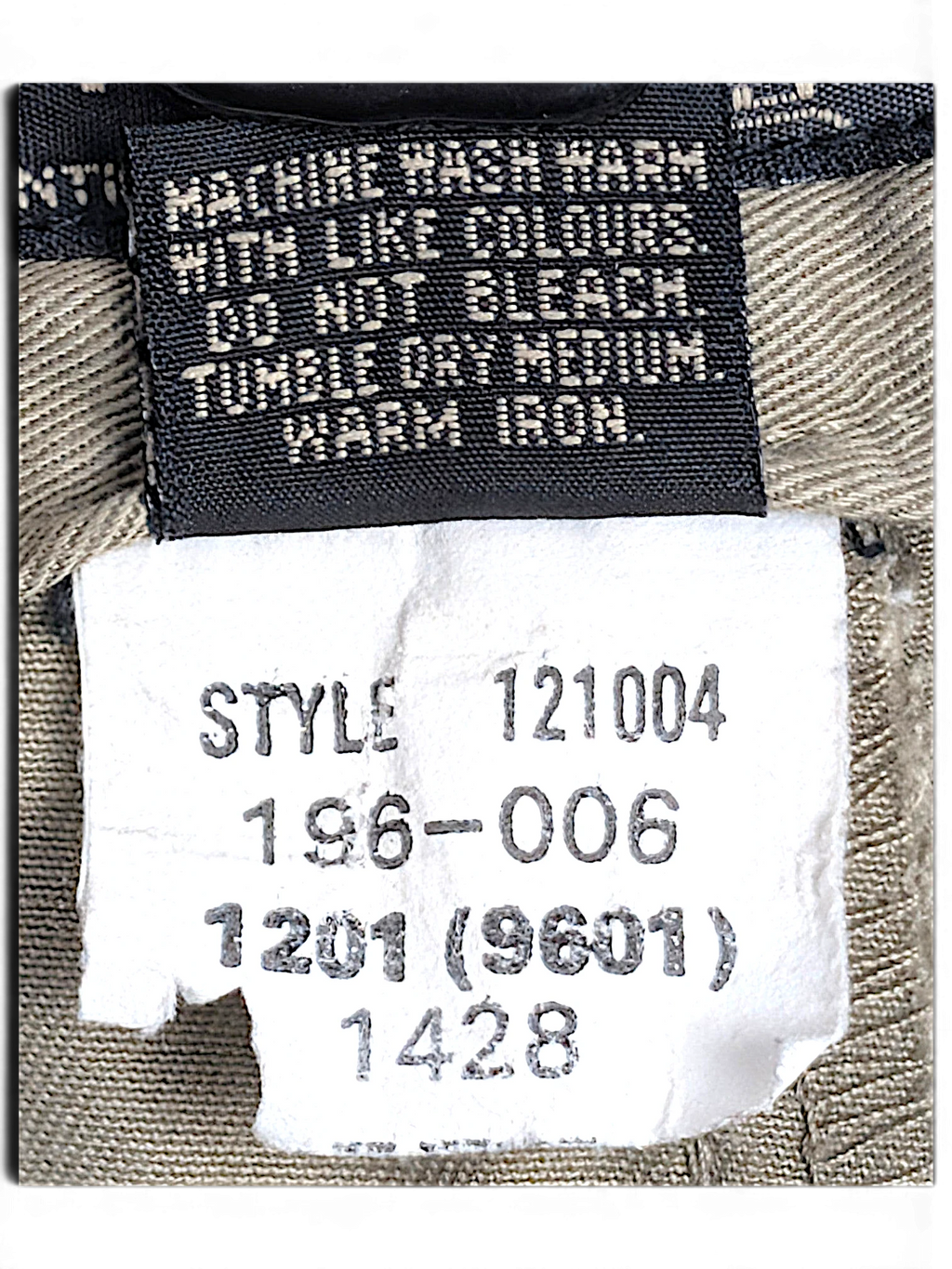 JAKE & IPI Jeanswest trousers care label showing style number 121004 and washing instructions on light grey fabric