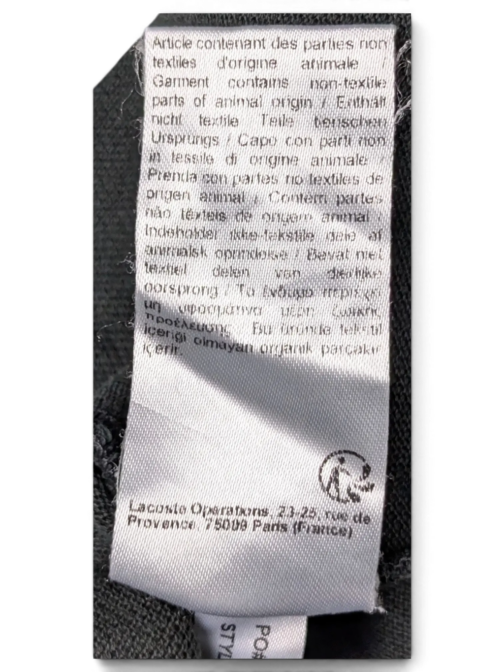 JAKE & IPI Lacoste black polo shirt interior care label with multi-language animal origin warning text
