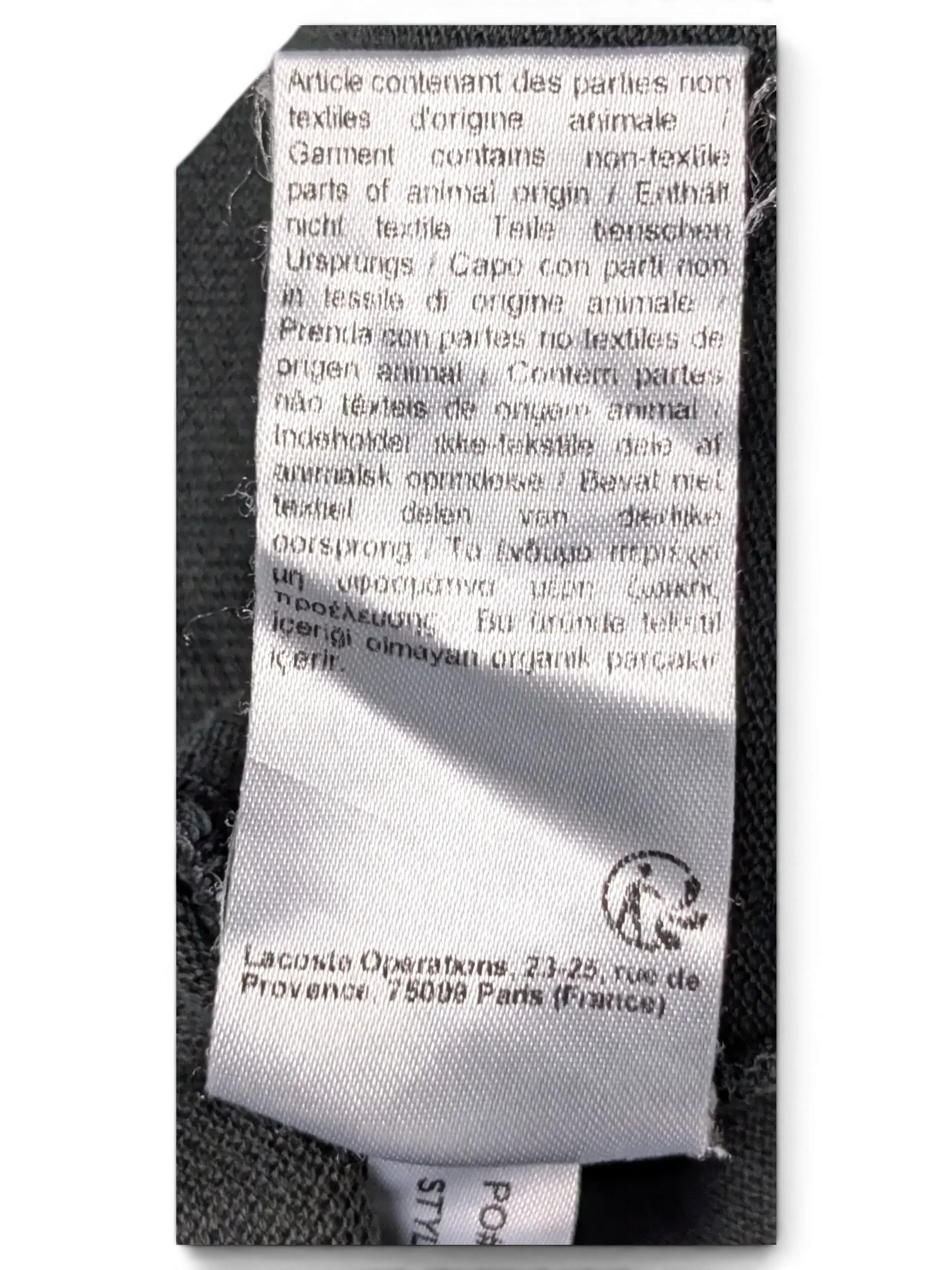 JAKE & IPI Lacoste black polo shirt interior care label with multi-language animal origin warning text