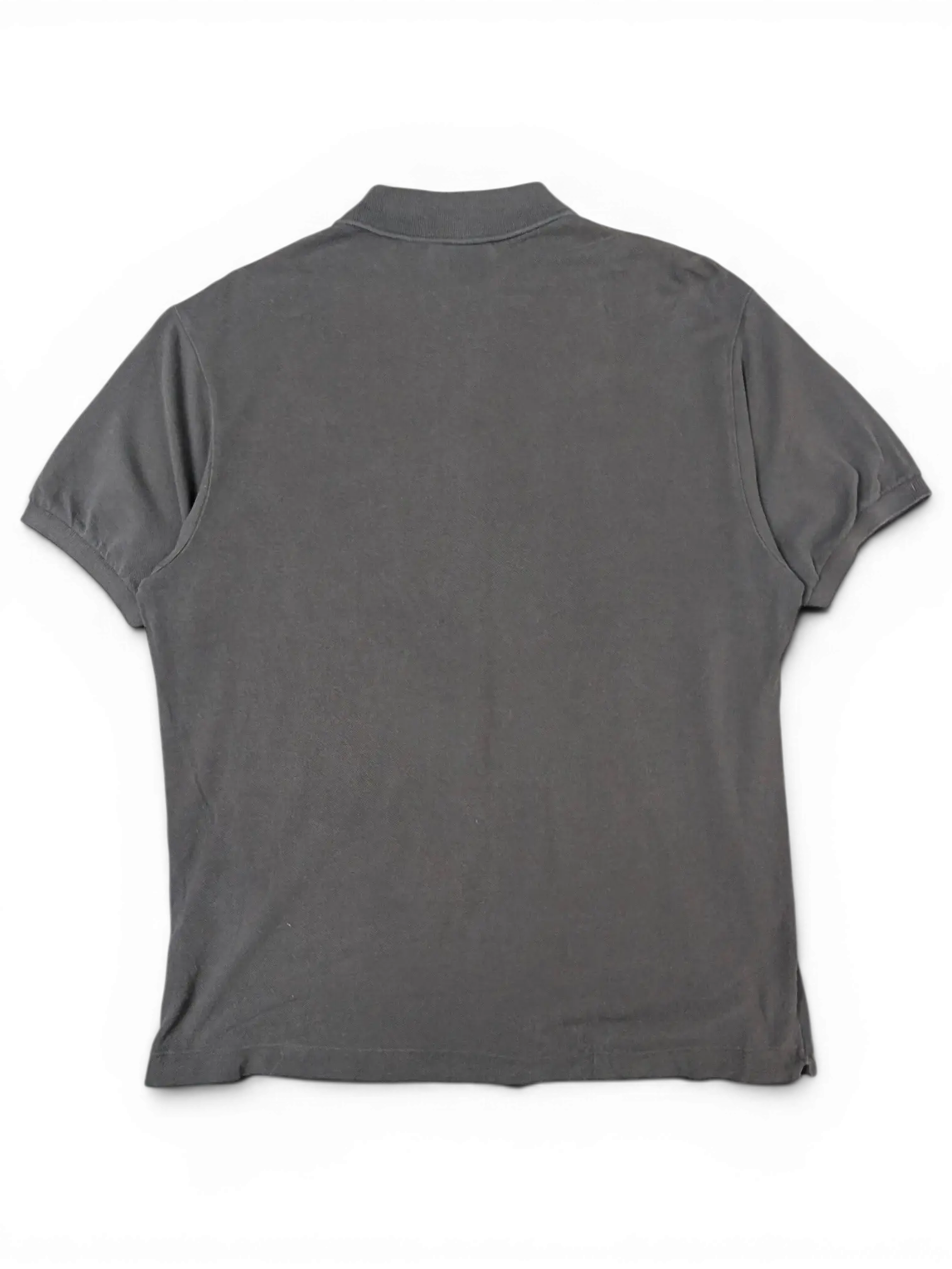 Back view of a black Lacoste polo shirt from JAKE & IPI, featuring a classic collar and short sleeves.
