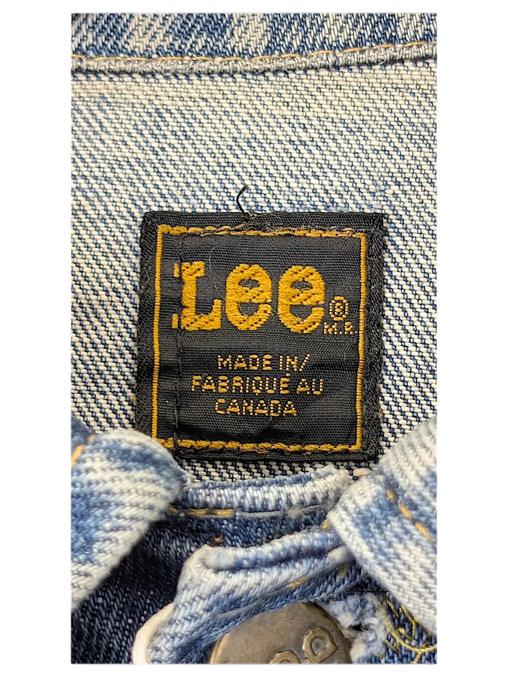 JAKE & IPI vintage LEE denim jacket label made in Canada with yellow embroidery on a dark blue fabric tag