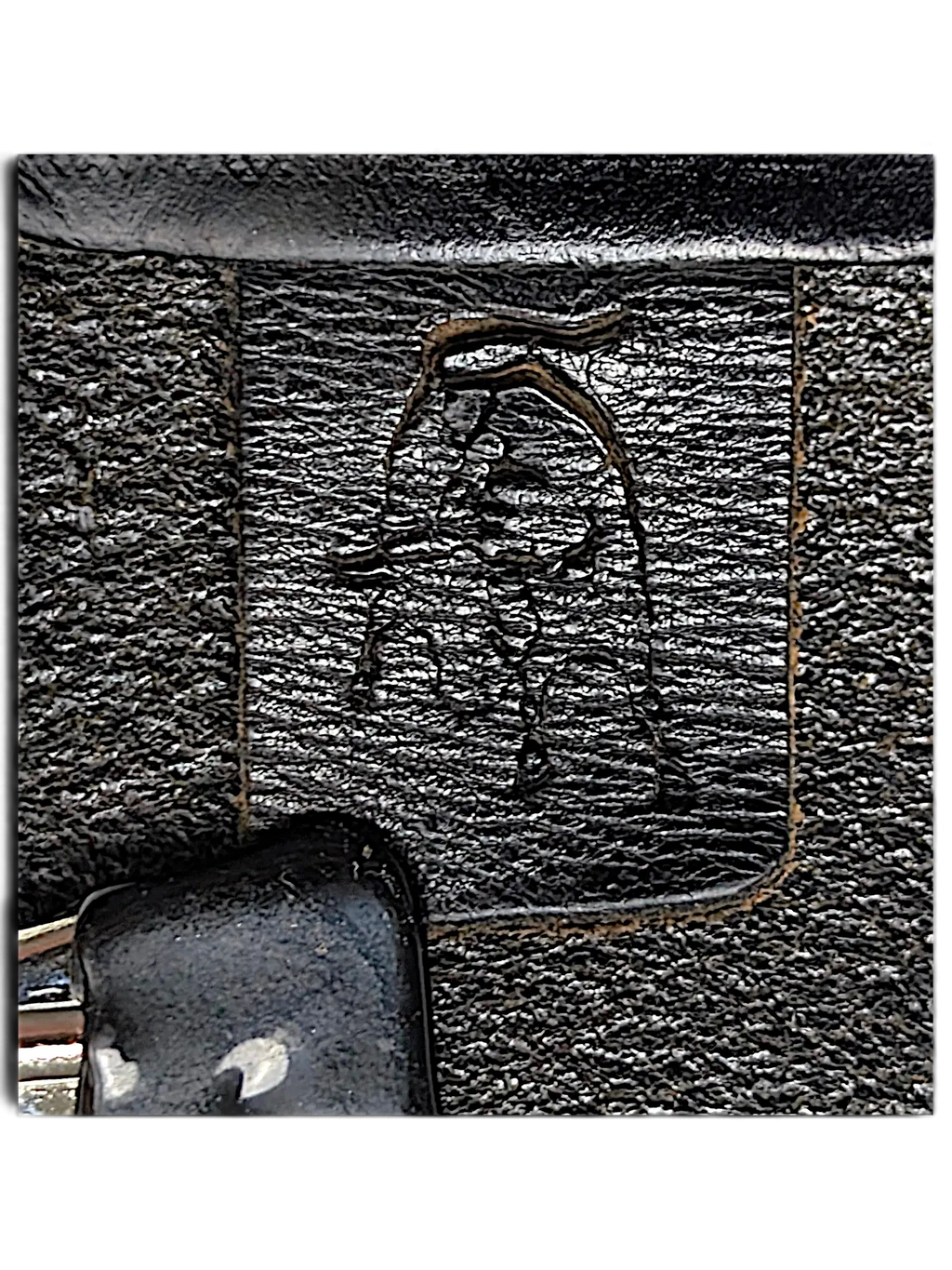 Close-up of JAKE & IPI Legend black leather belt featuring a debossed logo and visible contrast stitching.