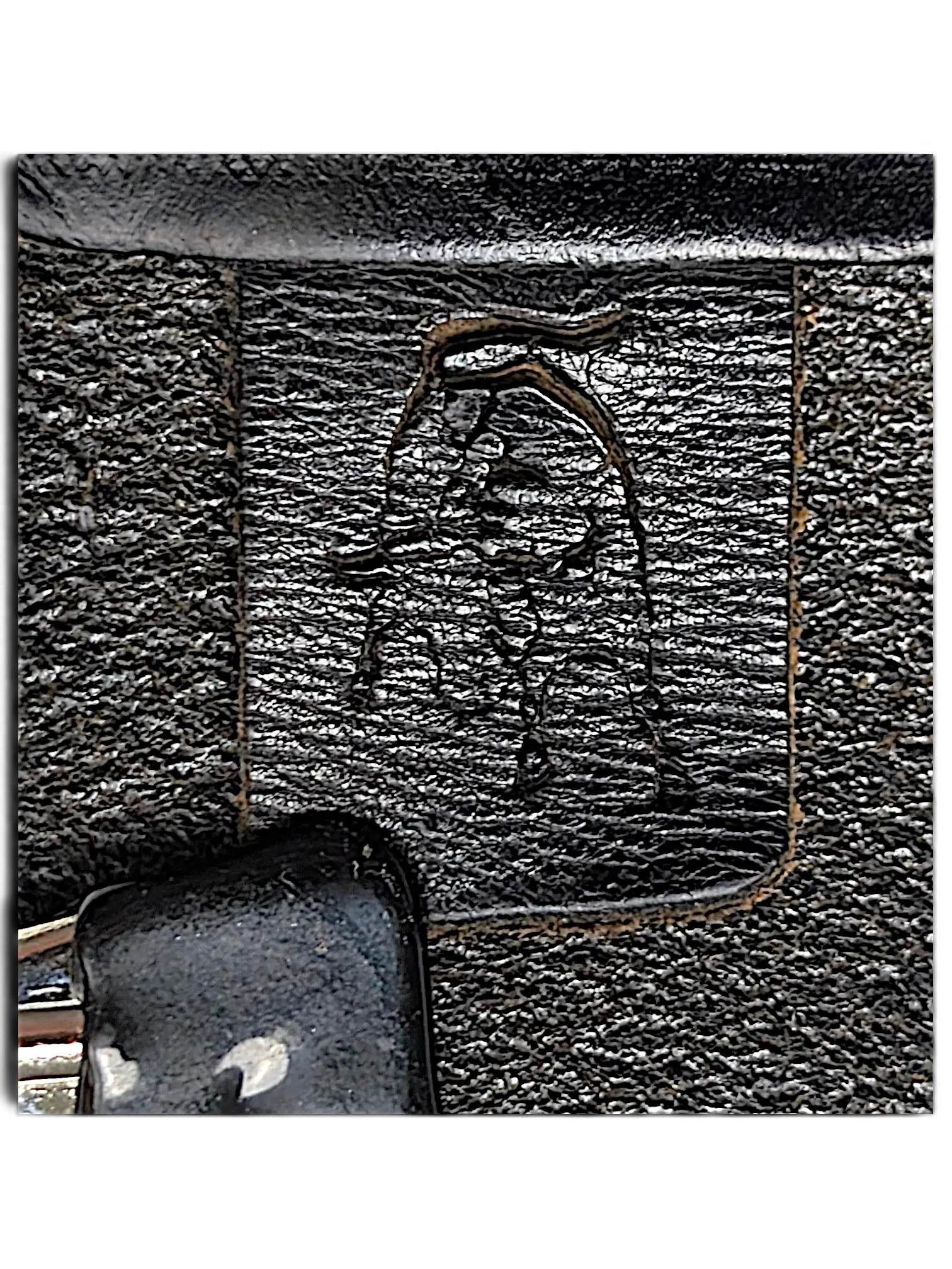 Close-up of JAKE & IPI Legend black leather belt featuring a debossed logo and visible contrast stitching.