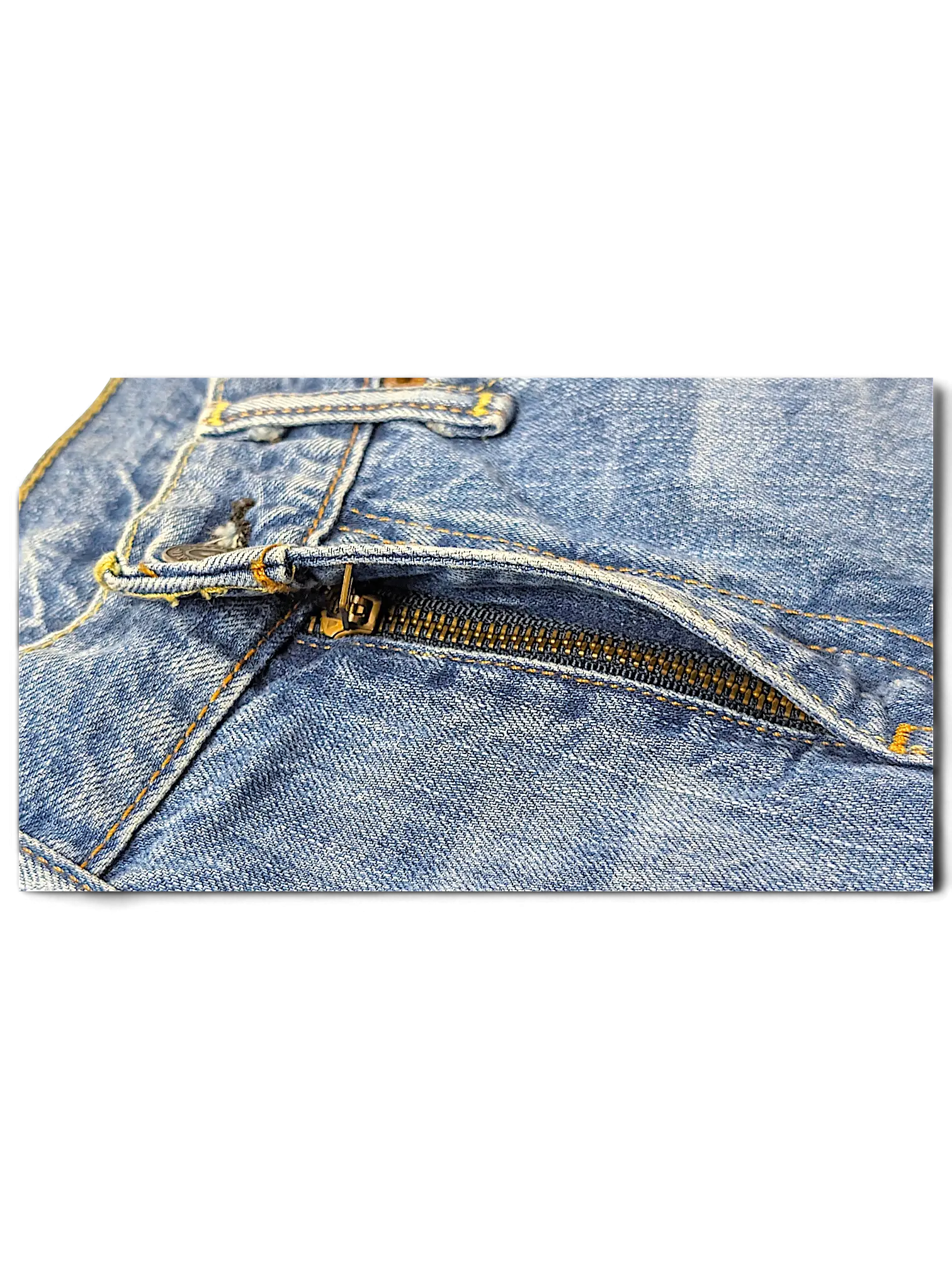 Close-up of the metal zipper and blue denim fabric on JAKE & IPI Levi's 511 ripped jeans.