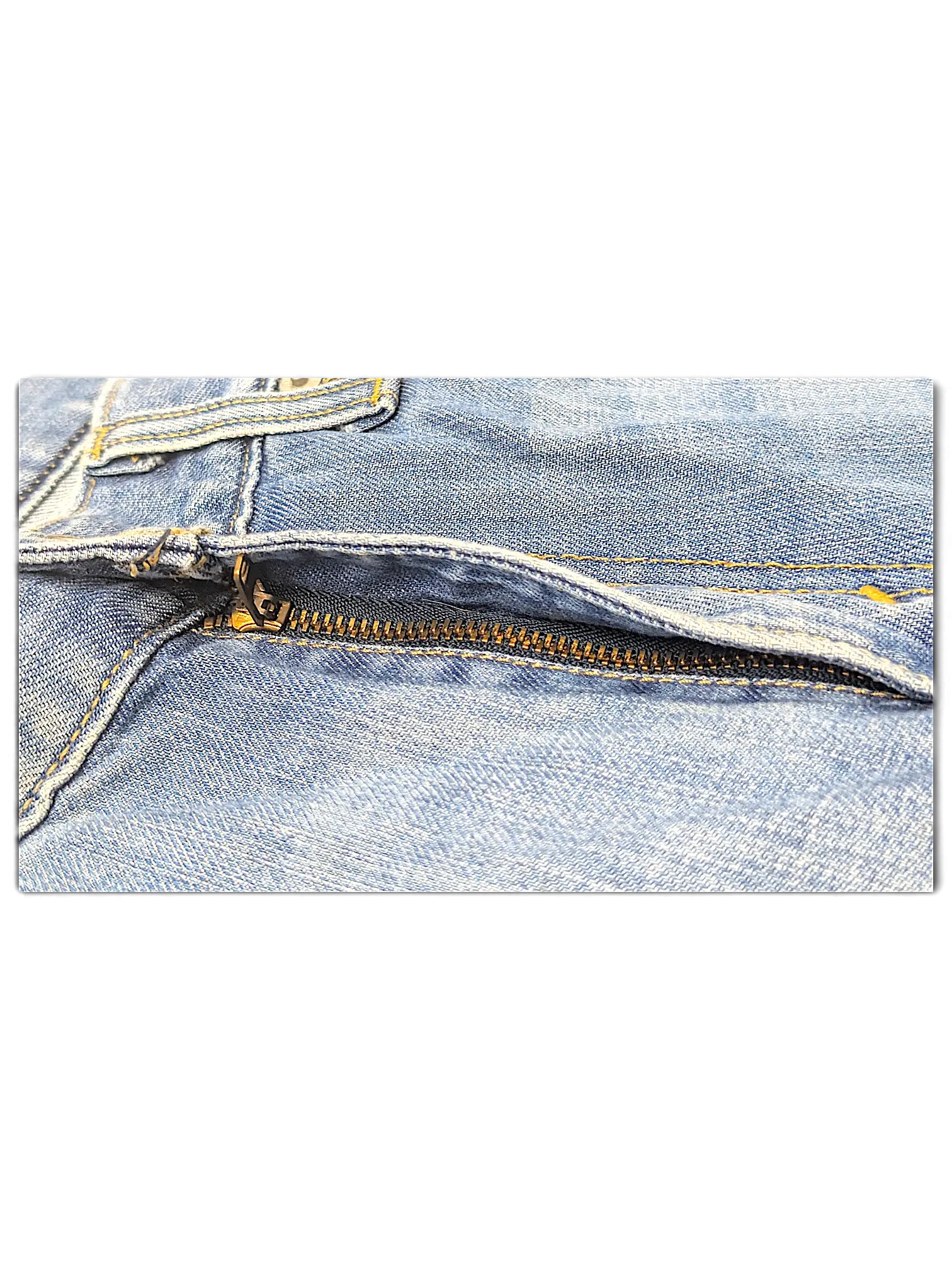 Close-up of the metal zipper and blue denim fabric on JAKE & IPI Levi's 514 jeans.