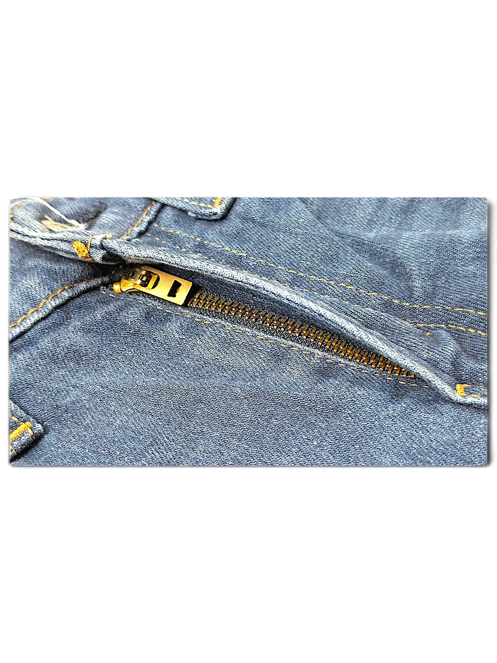 Close-up of the metal zipper and blue denim fabric of Levi's 514 jeans from JAKE & IPI