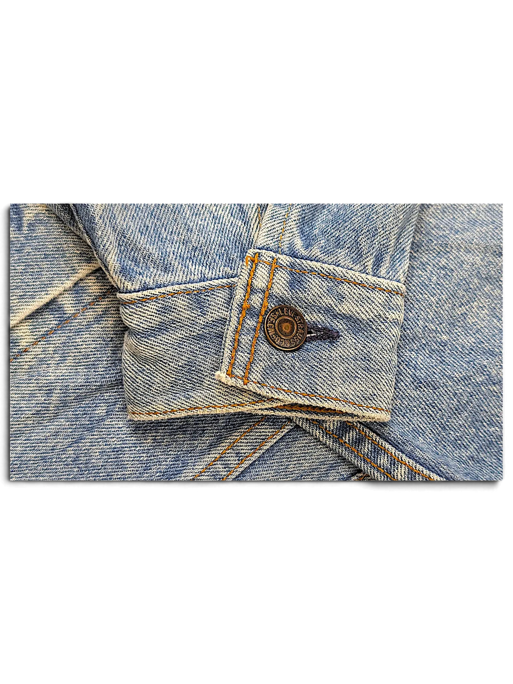 JAKE & IPI light wash denim jacket sleeve cuff featuring a branded Levi's metal button with contrast stitching