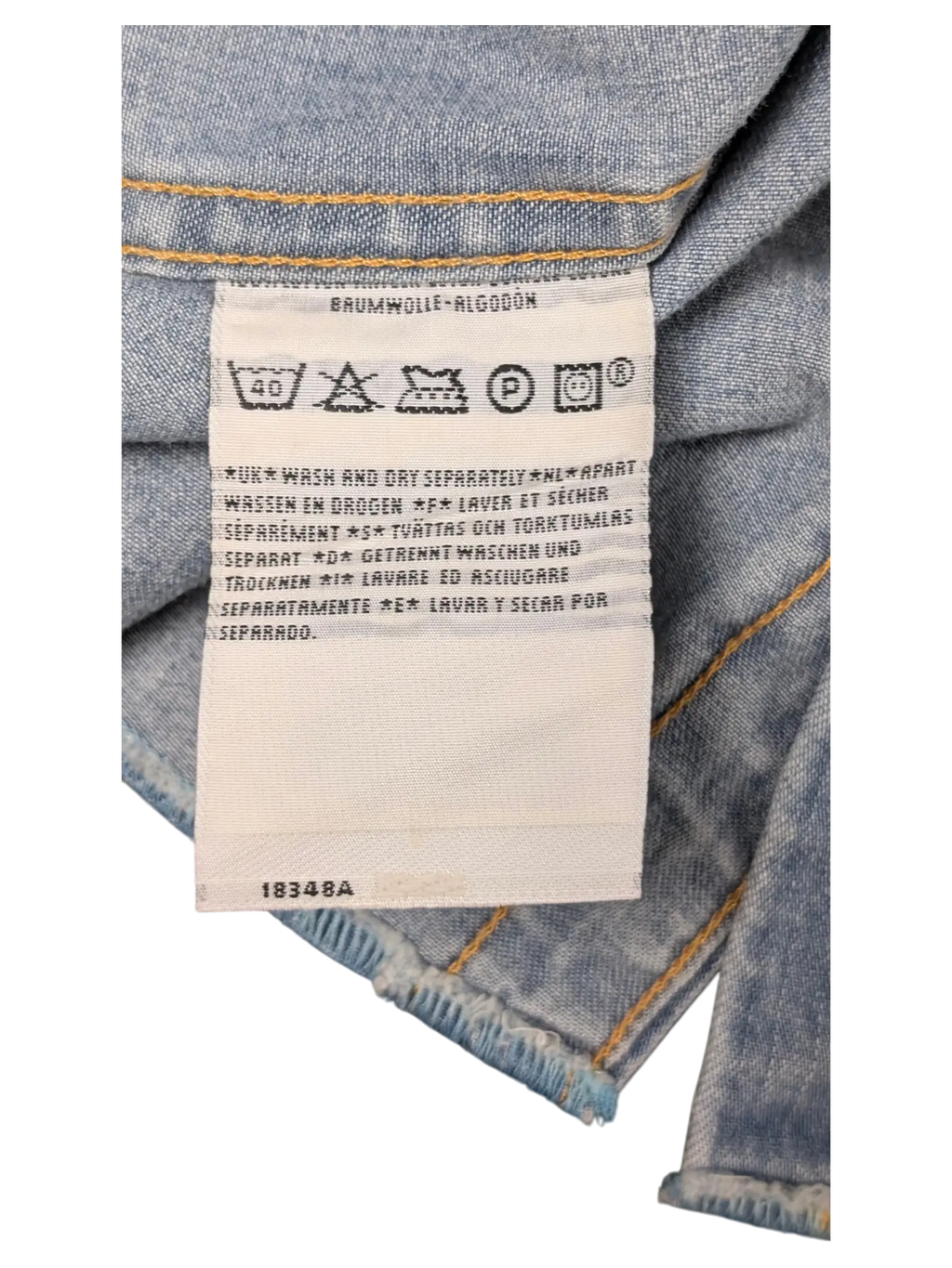 JAKE & IPI Levi's denim shirt care label with washing instructions in multiple languages on light blue denim fabric