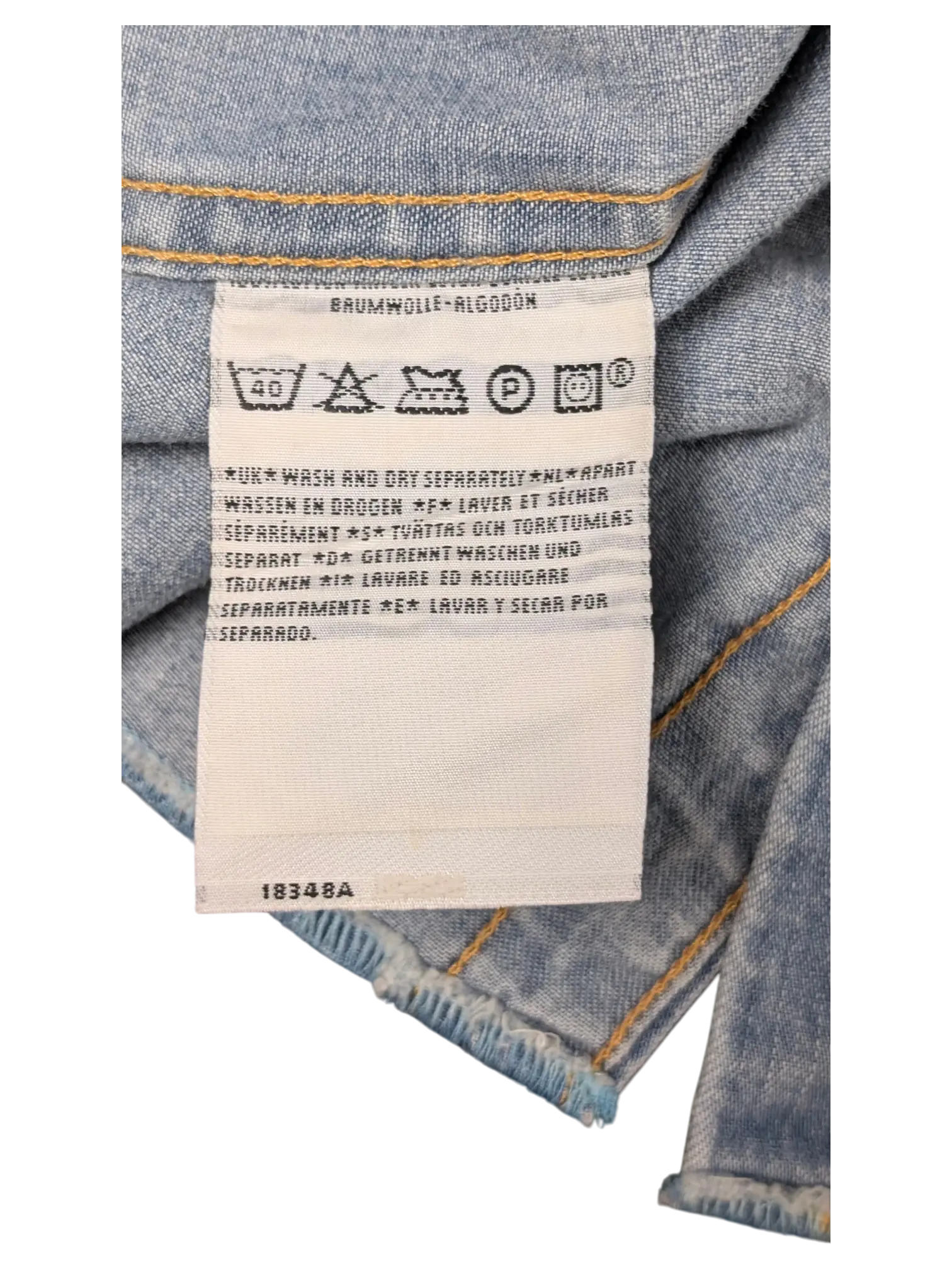JAKE & IPI Levi's denim shirt care label with washing instructions in multiple languages on light blue denim fabric