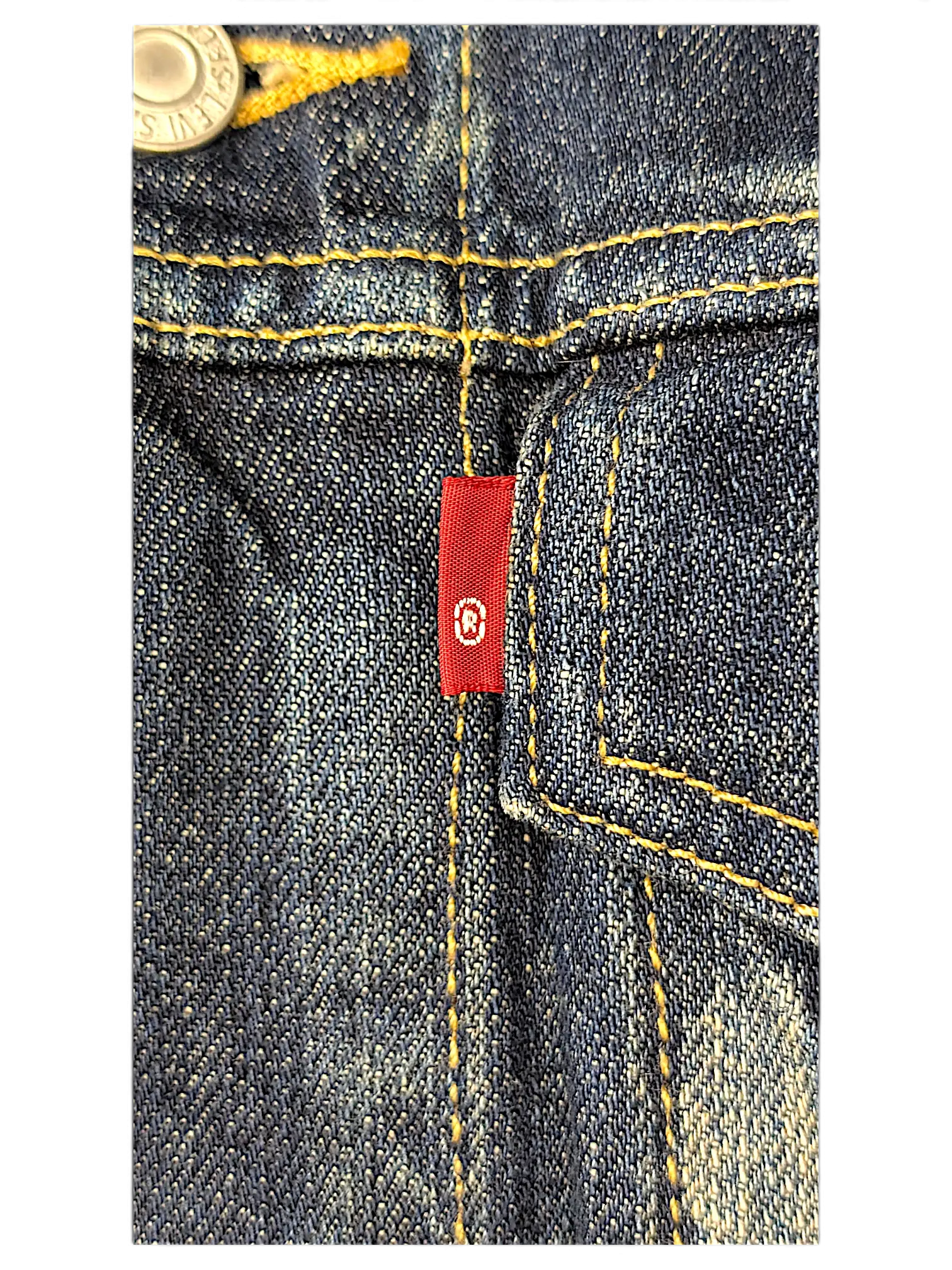 Close-up of a JAKE & IPI Levi's denim vest featuring dark blue fabric, contrast yellow stitching, and a red tab detail.