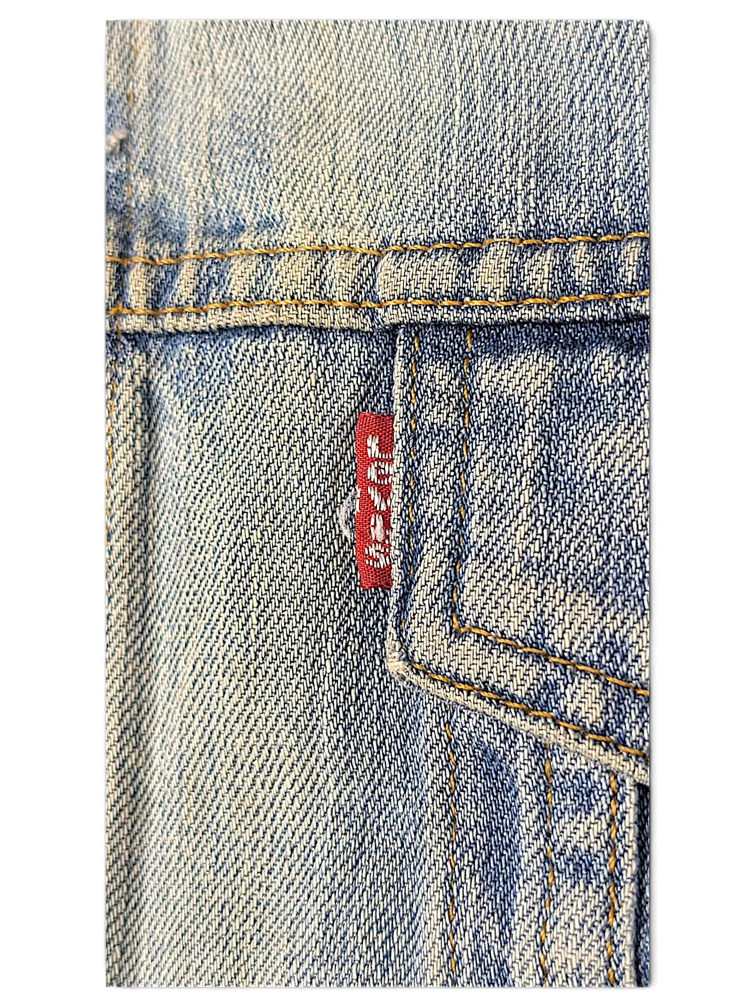 Close-up of a JAKE & IPI Levi's distressed washed blue denim jacket featuring a red brand tab on the chest pocket.