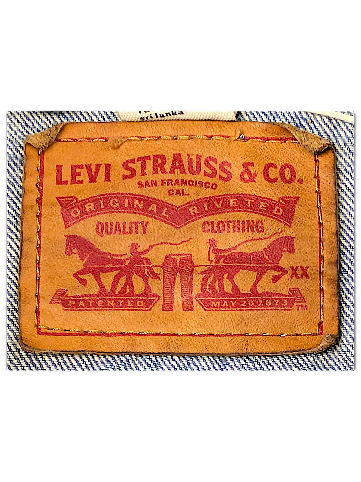 JAKE & IPI Levi Strauss and Co brown leather brand patch on a light blue denim jacket