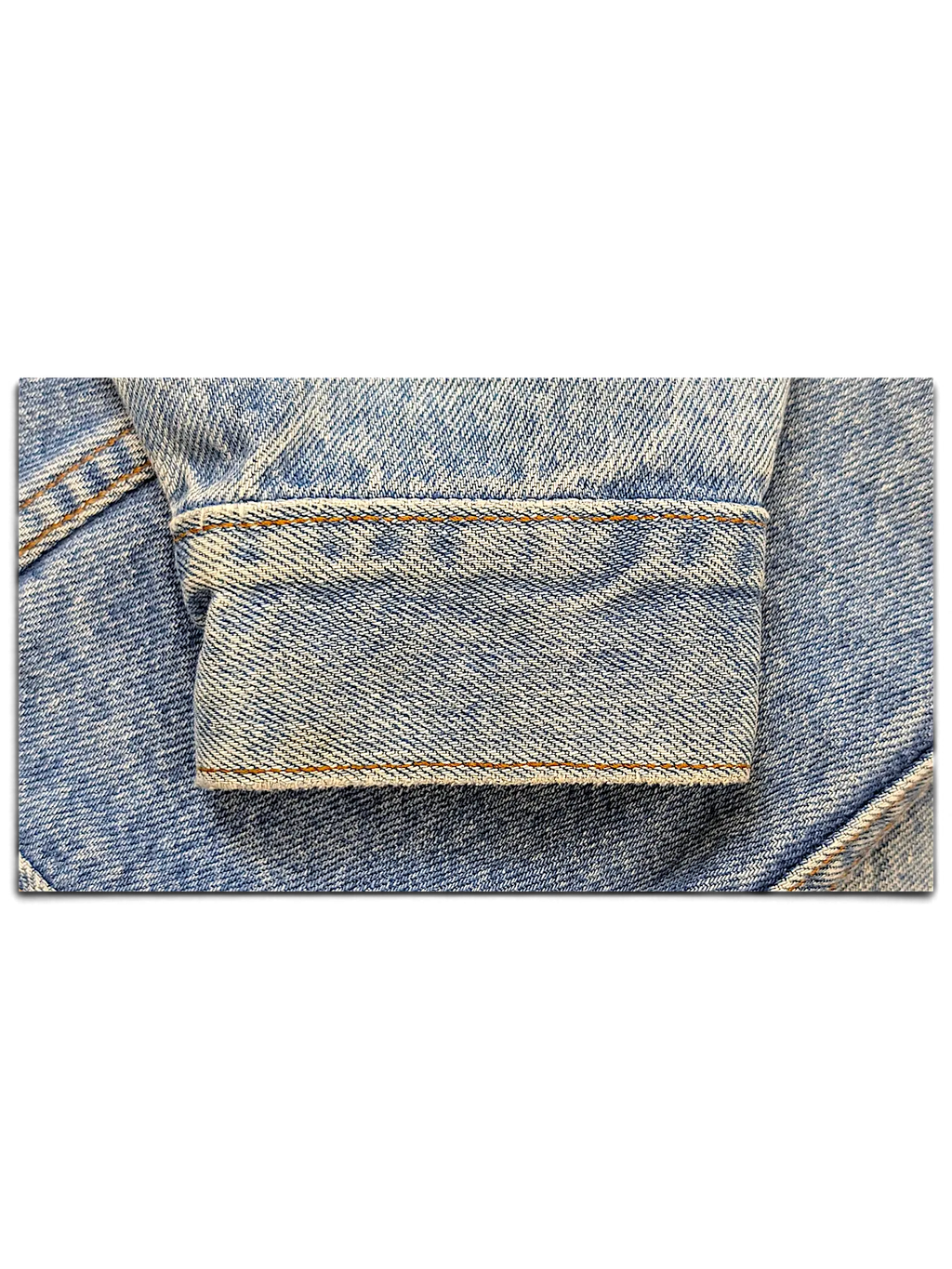 Close-up of a light blue denim jacket cuff with visible stitching from JAKE & IPI