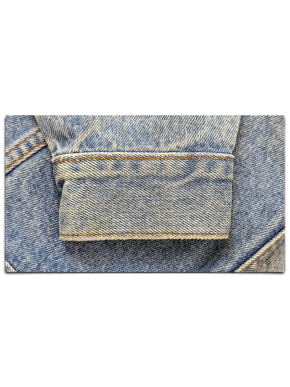 Close-up of a light blue denim jacket cuff with visible stitching from JAKE & IPI