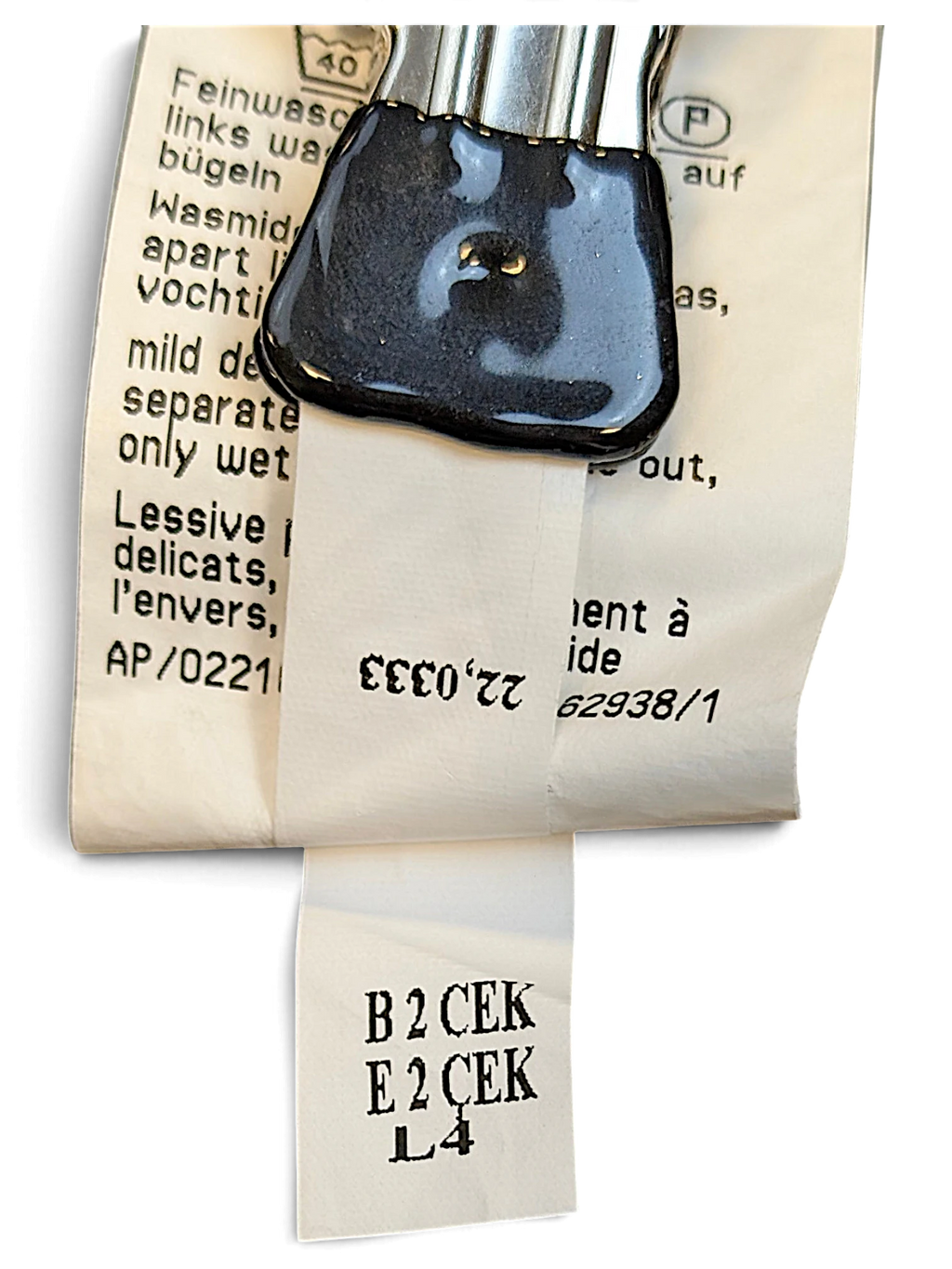 JAKE & IPI MAC Jeans garment care label with washing instructions and production codes on white fabric