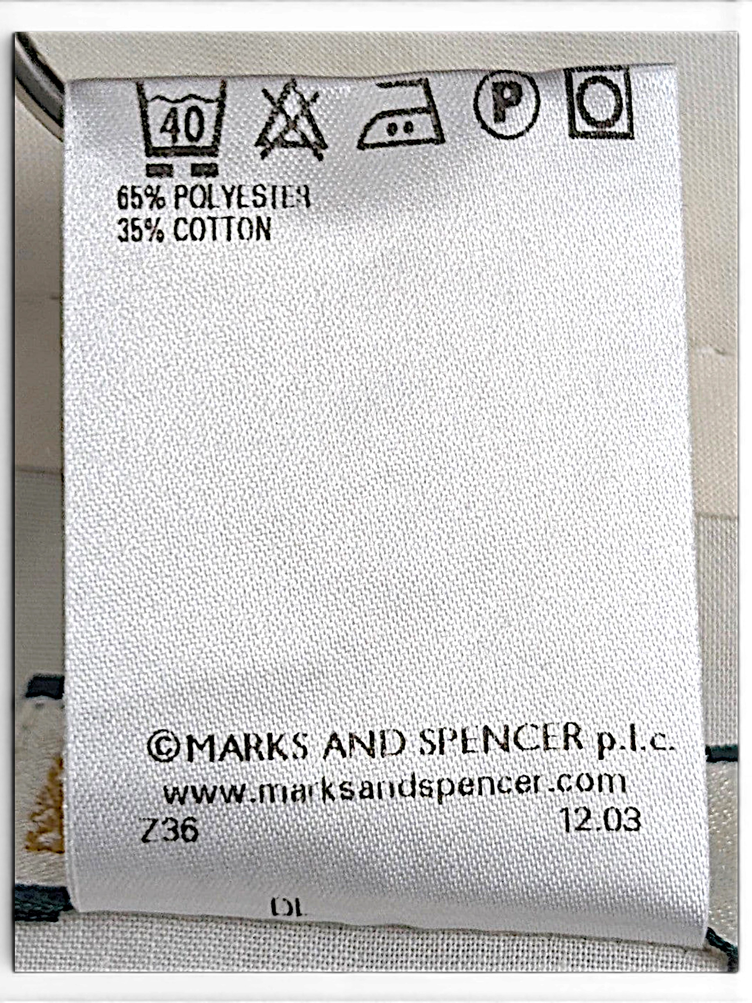 JAKE & IPI Marks & Spencer clothing care label showing 65 percent polyester and 35 percent cotton fabric composition