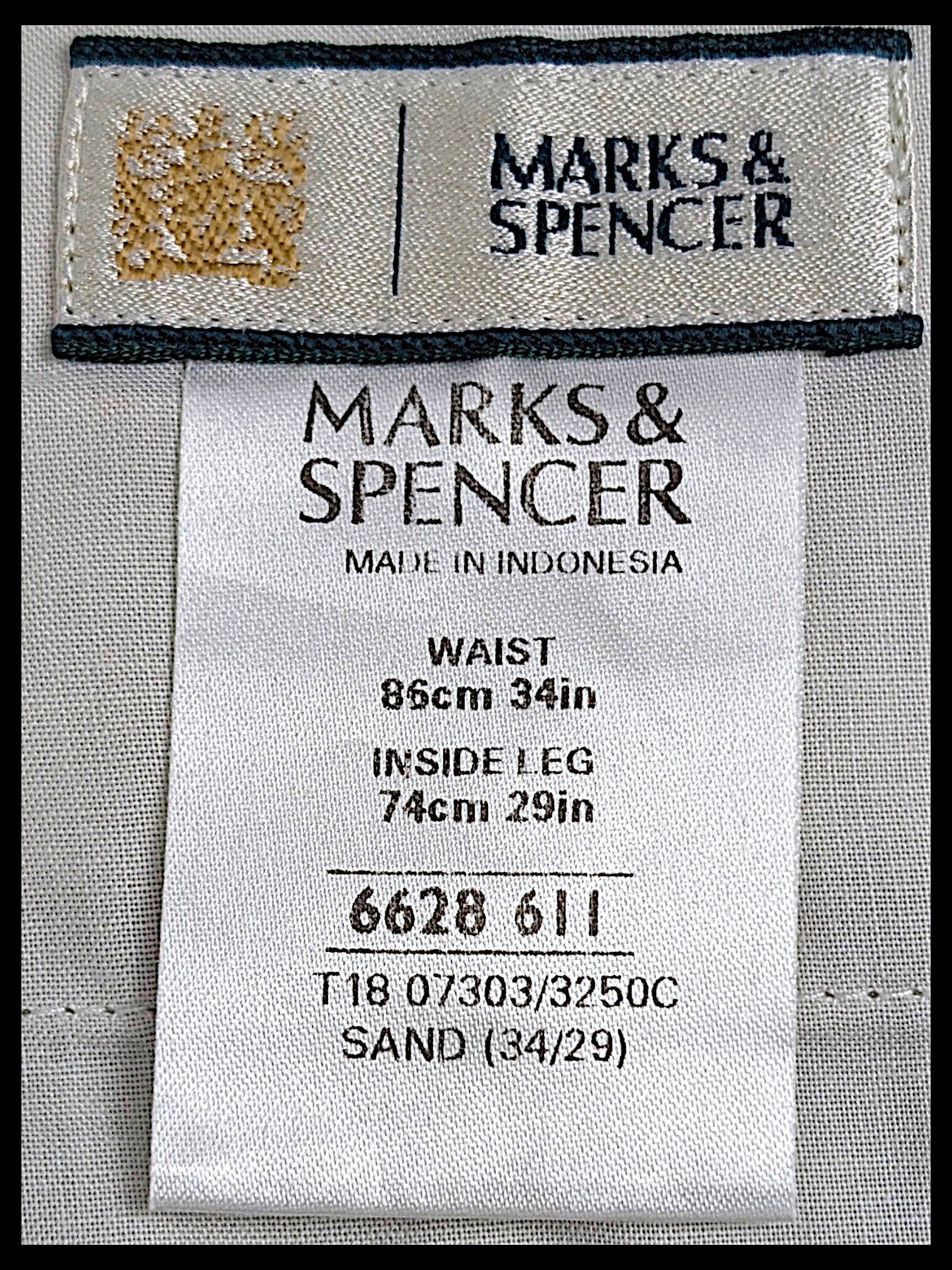 JAKE & IPI Marks & Spencer clothing label showing size W34 L29 and sand colour code on beige cotton-blend fabric