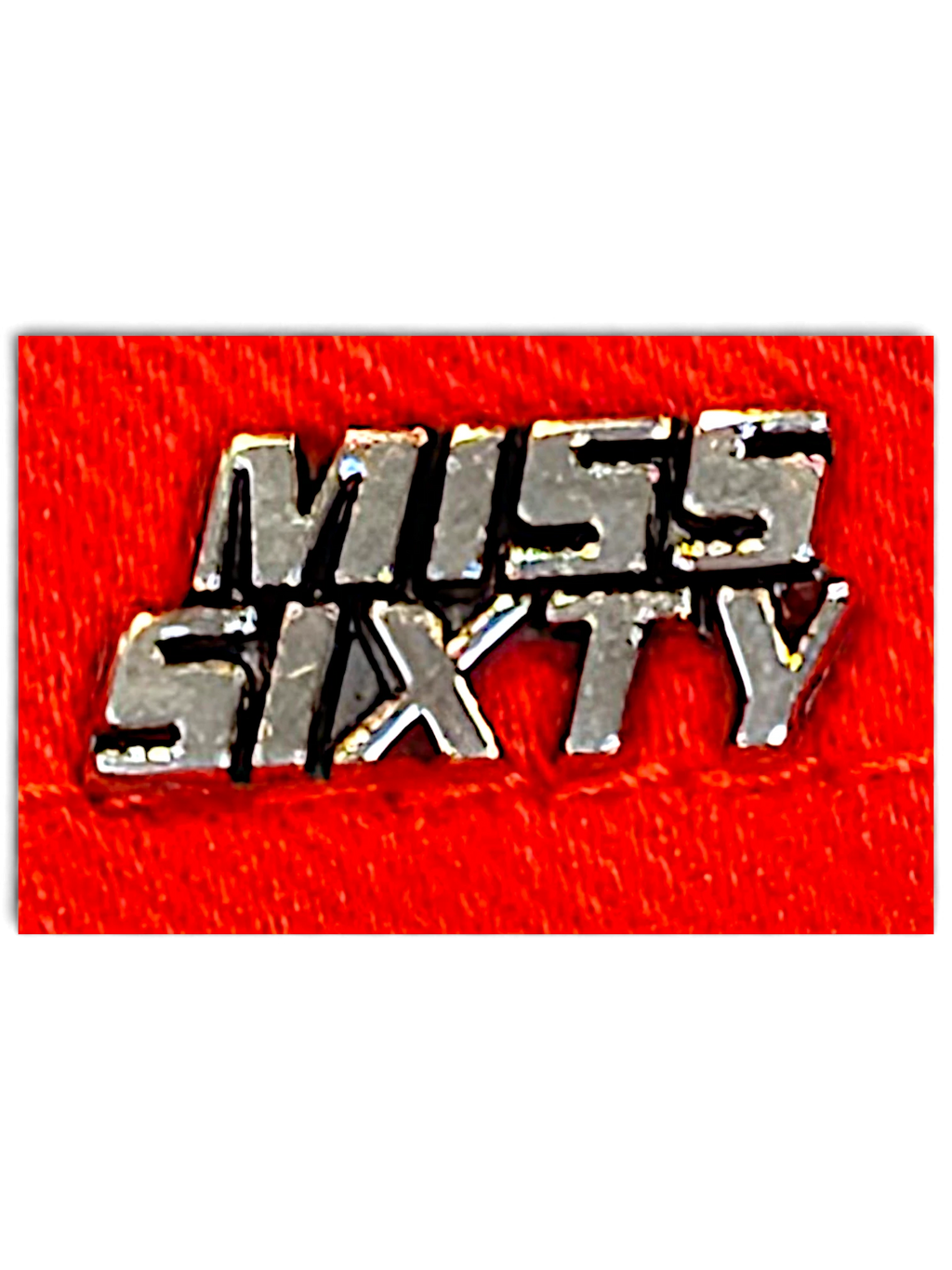 JAKE & IPI Miss Sixty red denim jeans featuring a metallic silver brand logo plaque on a vibrant red fabric background