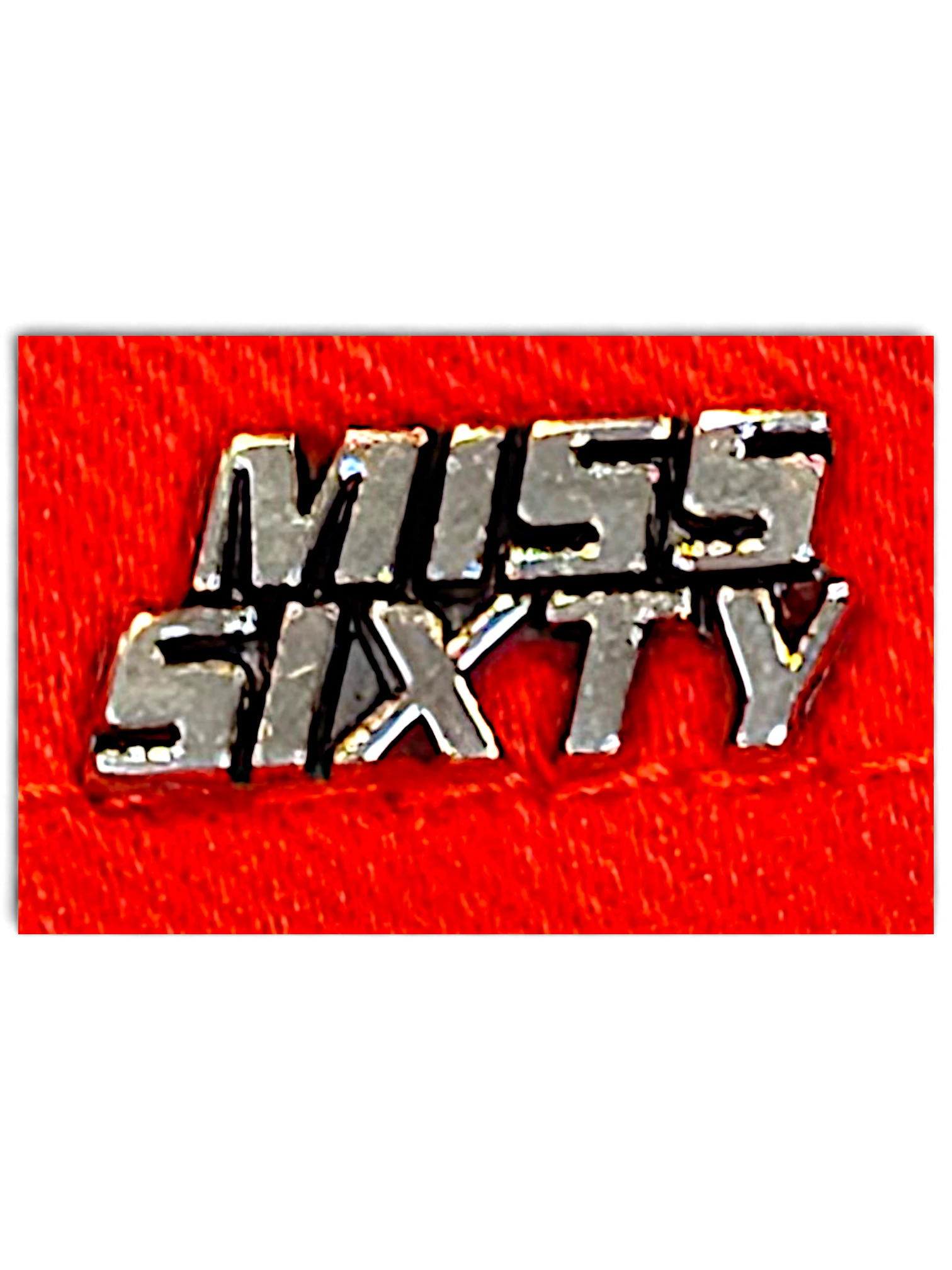 JAKE & IPI Miss Sixty red denim jeans featuring a metallic silver brand logo plaque on a vibrant red fabric background