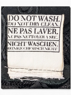 JAKE & IPI IBE Morivelle cap fabric care label with do not wash and do not dry clean instructions in three languages