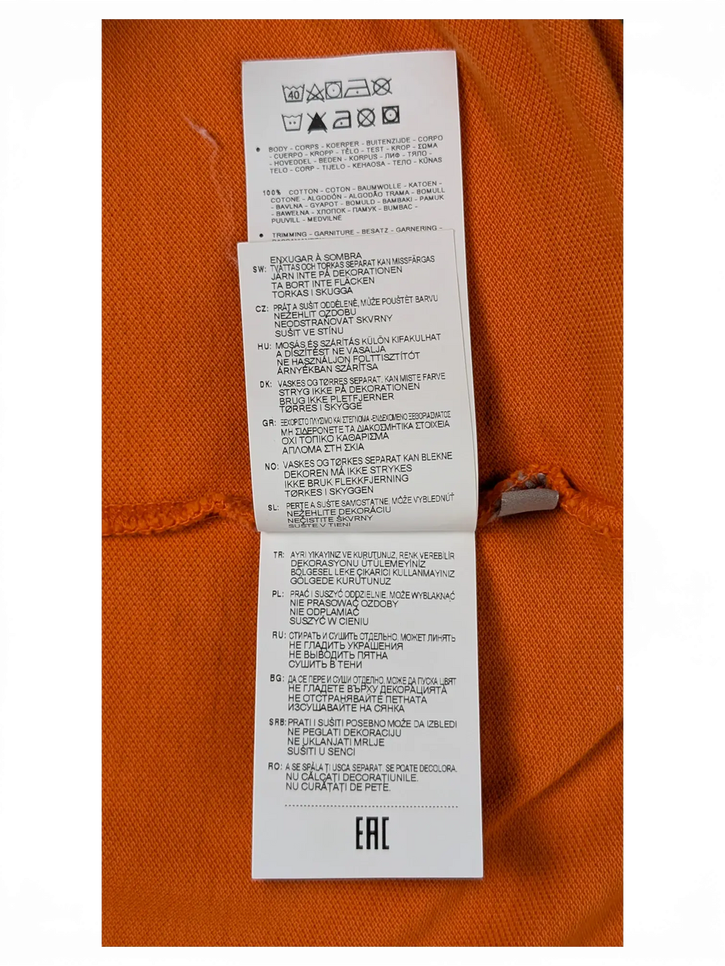 JAKE & IPI Napapijri orange polo shirt care label showing 100% cotton material composition and washing instructions