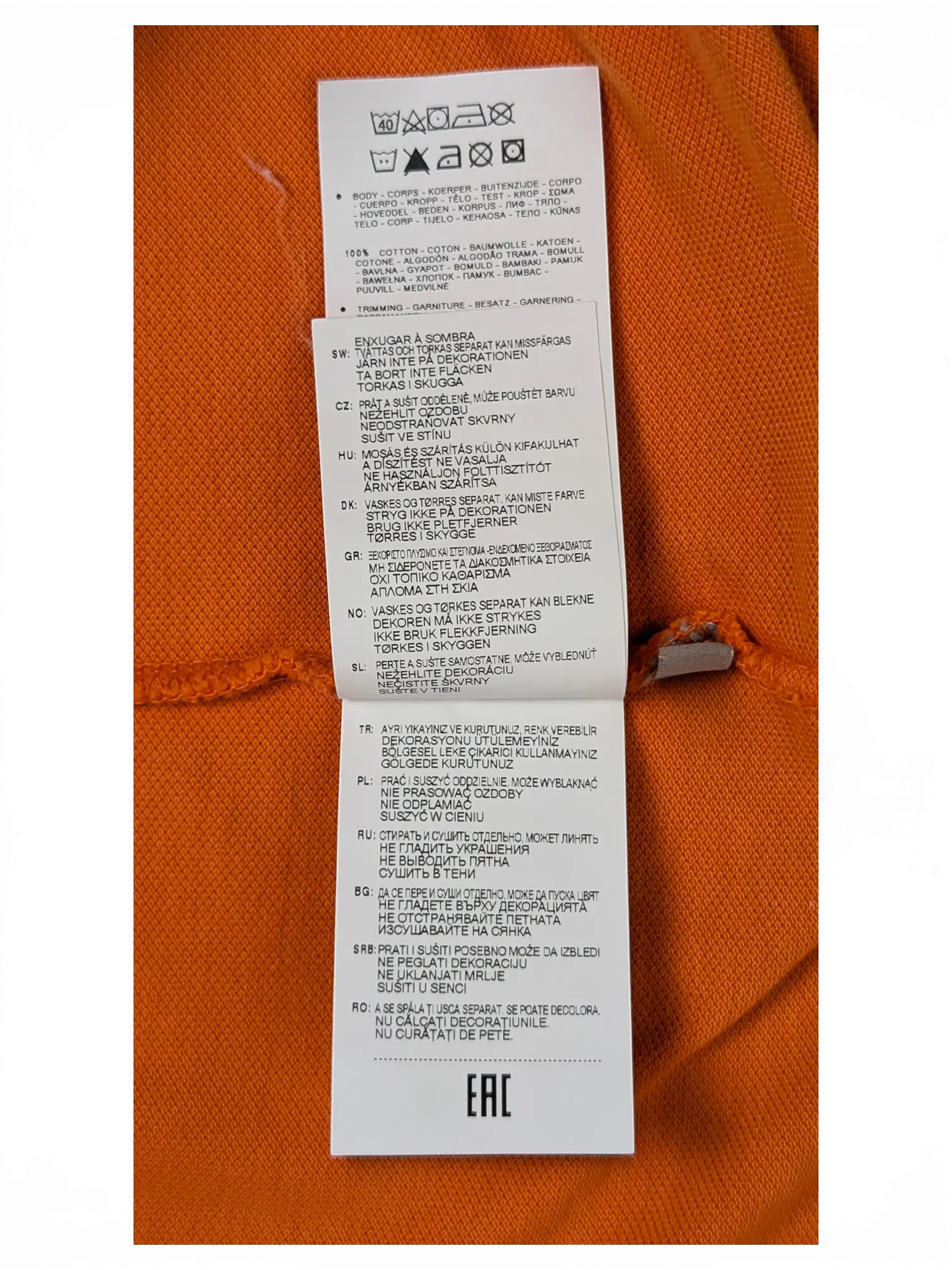 JAKE & IPI Napapijri orange polo shirt care label showing 100% cotton material composition and washing instructions