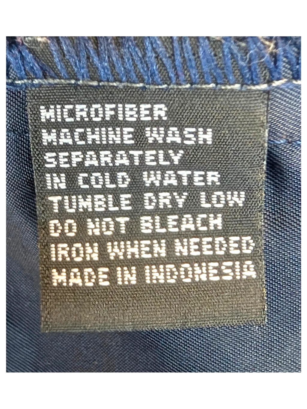 JAKE & IPI navy blue microfiber shirt care label with washing instructions and country of origin