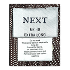 JAKE & IPI Next brand clothing label on brown and cream pinstripe cotton fabric with care instructions
