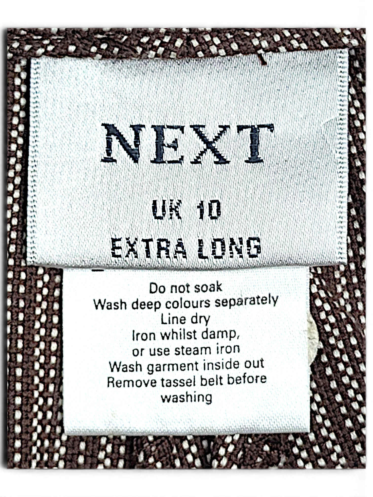JAKE & IPI Next brand clothing label on brown and cream pinstripe cotton fabric with care instructions