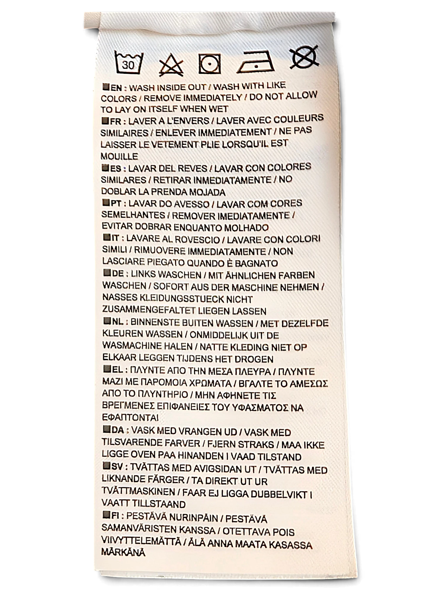 JAKE & IPI Nike track pants care label with washing instructions in multiple languages on a white polyester tag.