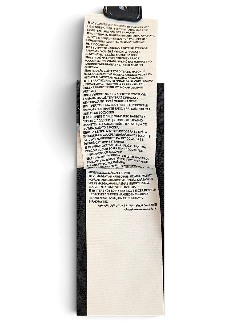 JAKE & IPI Nike track pants care instruction label with multi-language washing symbols and text on polyester fabric