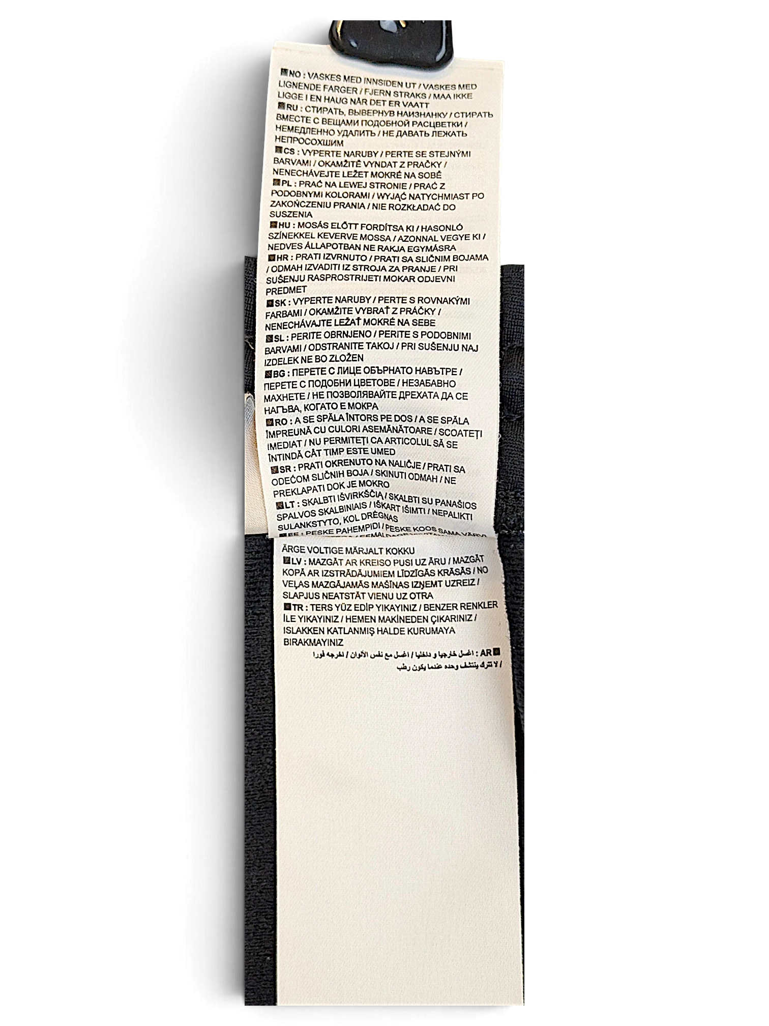 JAKE & IPI Nike track pants care instruction label with multi-language washing symbols and text on polyester fabric