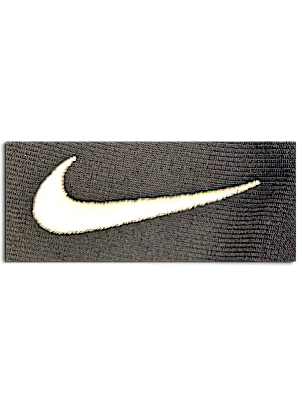 Close-up of a white embroidered Nike Swoosh logo on grey polyester fabric from JAKE & IPI track pants