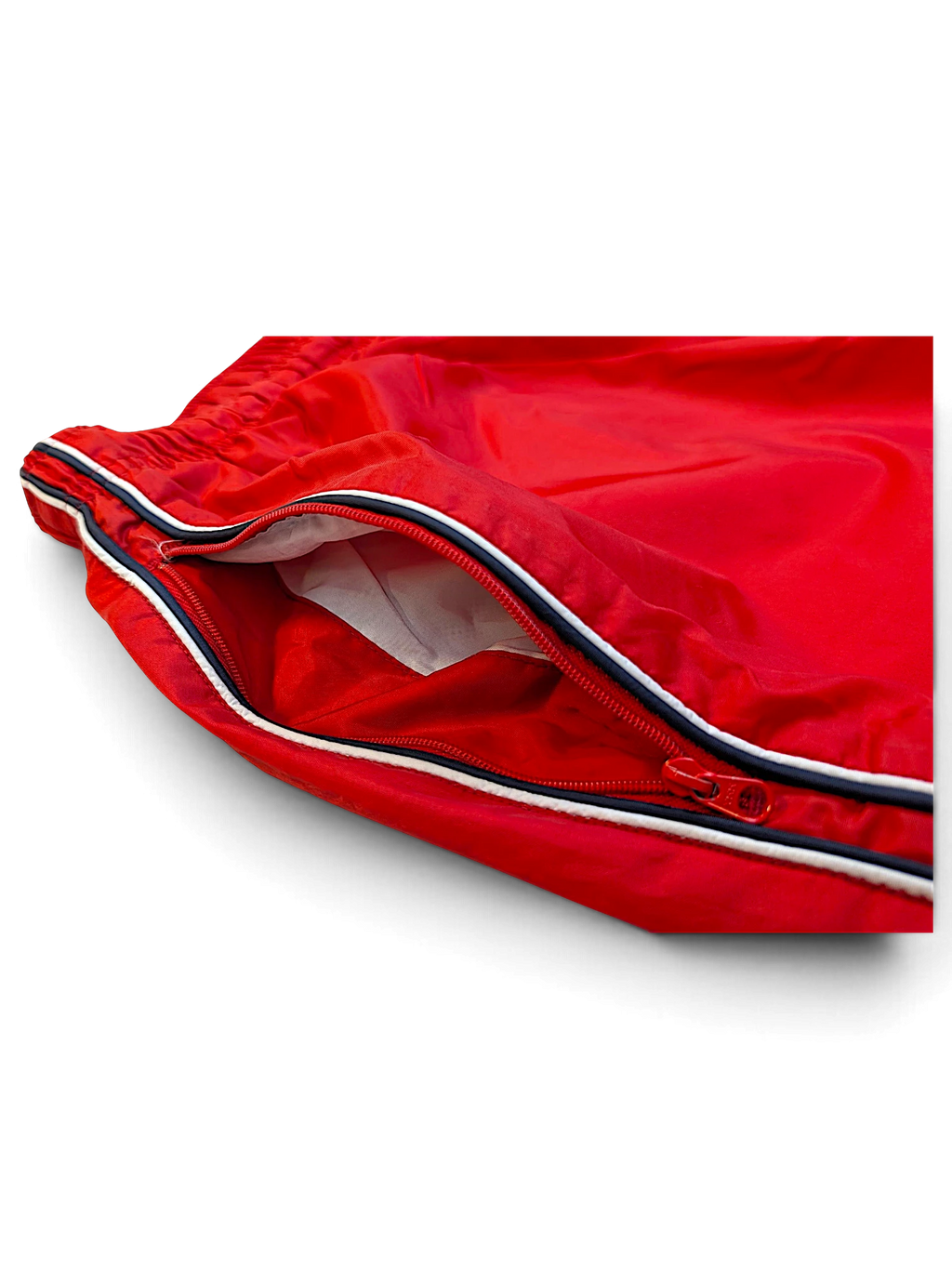 JAKE & IPI Nike red track pants featuring a zippered pocket with black and white side stripe detailing.