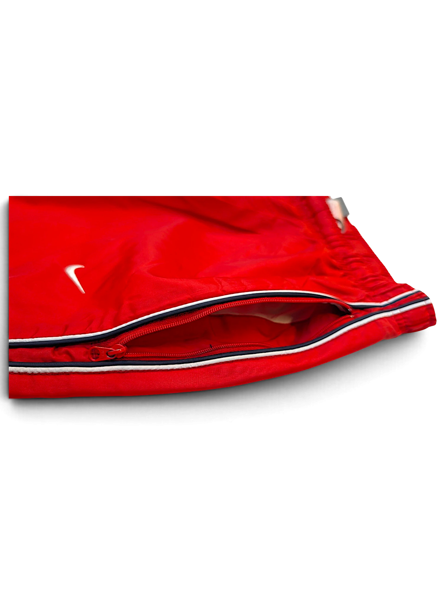 JAKE & IPI Nike red track pants featuring a zippered pocket, white Swoosh logo, and black and white side stripes.