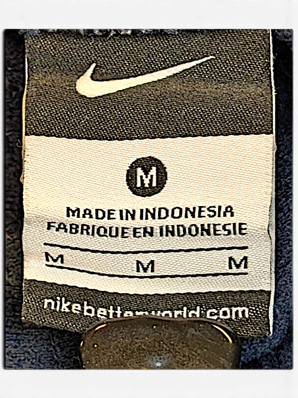 JAKE & IPI Nike track pants size M clothing label with Swoosh logo and Made in Indonesia text