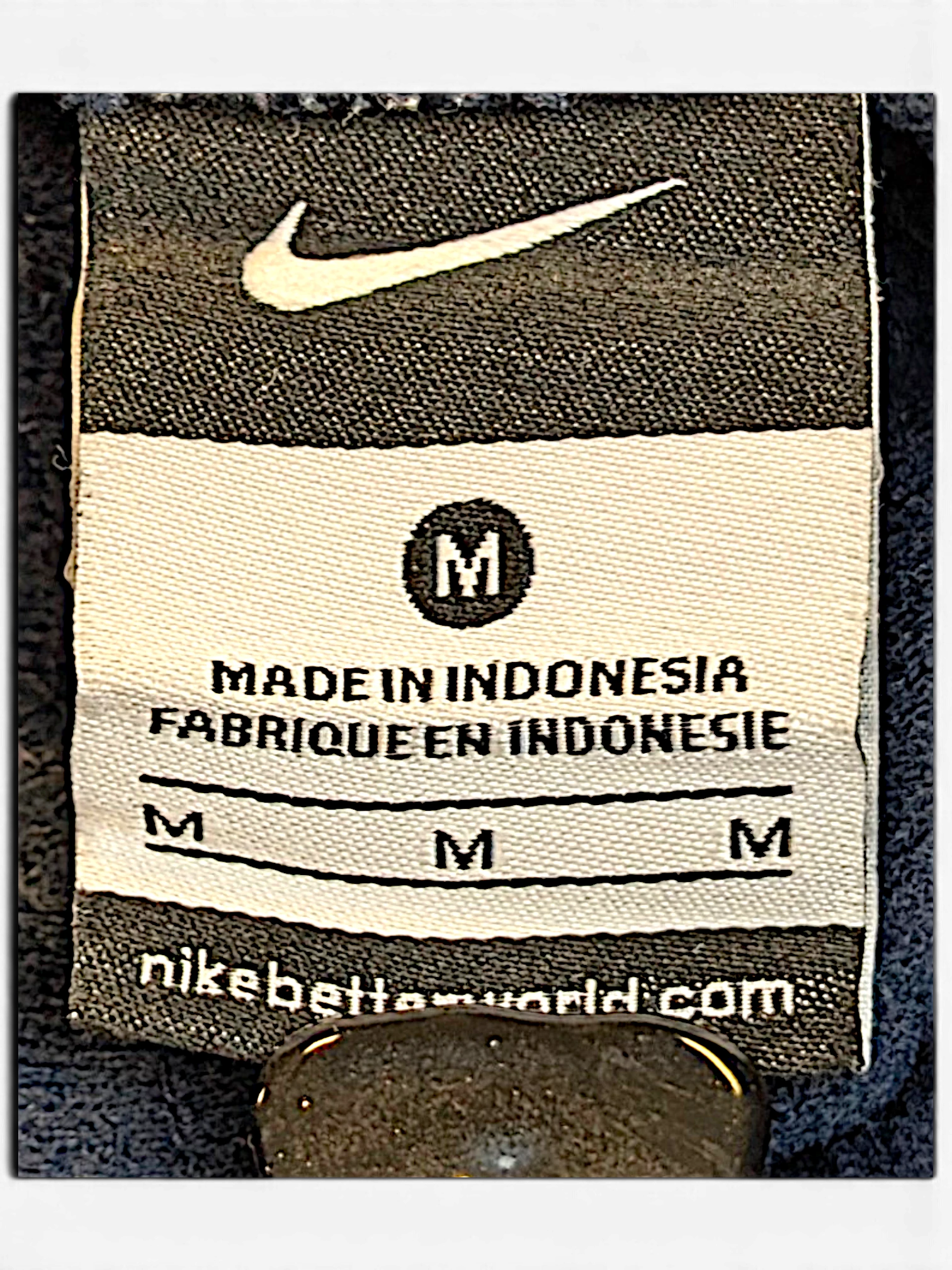 JAKE & IPI Nike track pants size M clothing label with Swoosh logo and Made in Indonesia text