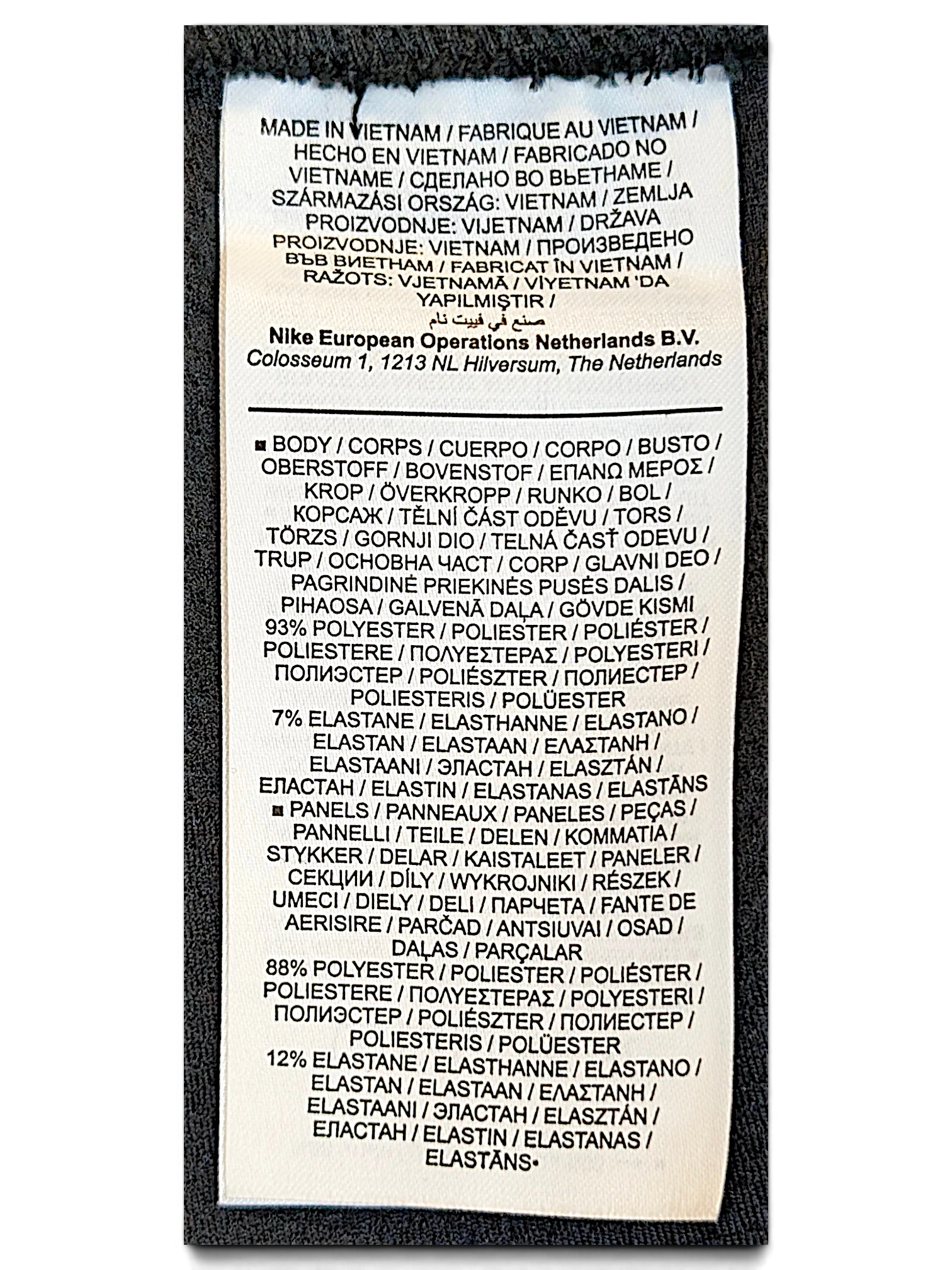 JAKE & IPI Nike track pants care label showing polyester and elastane fabric composition and Vietnam origin