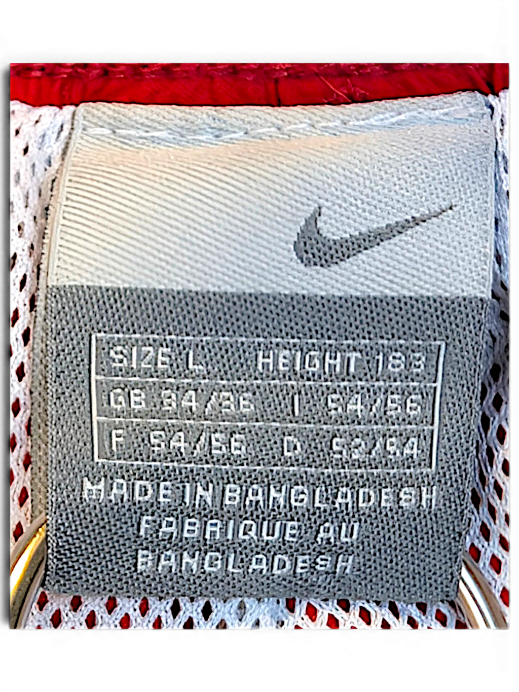 JAKE & IPI Nike track pants size L label showing Swoosh logo and manufacturing details