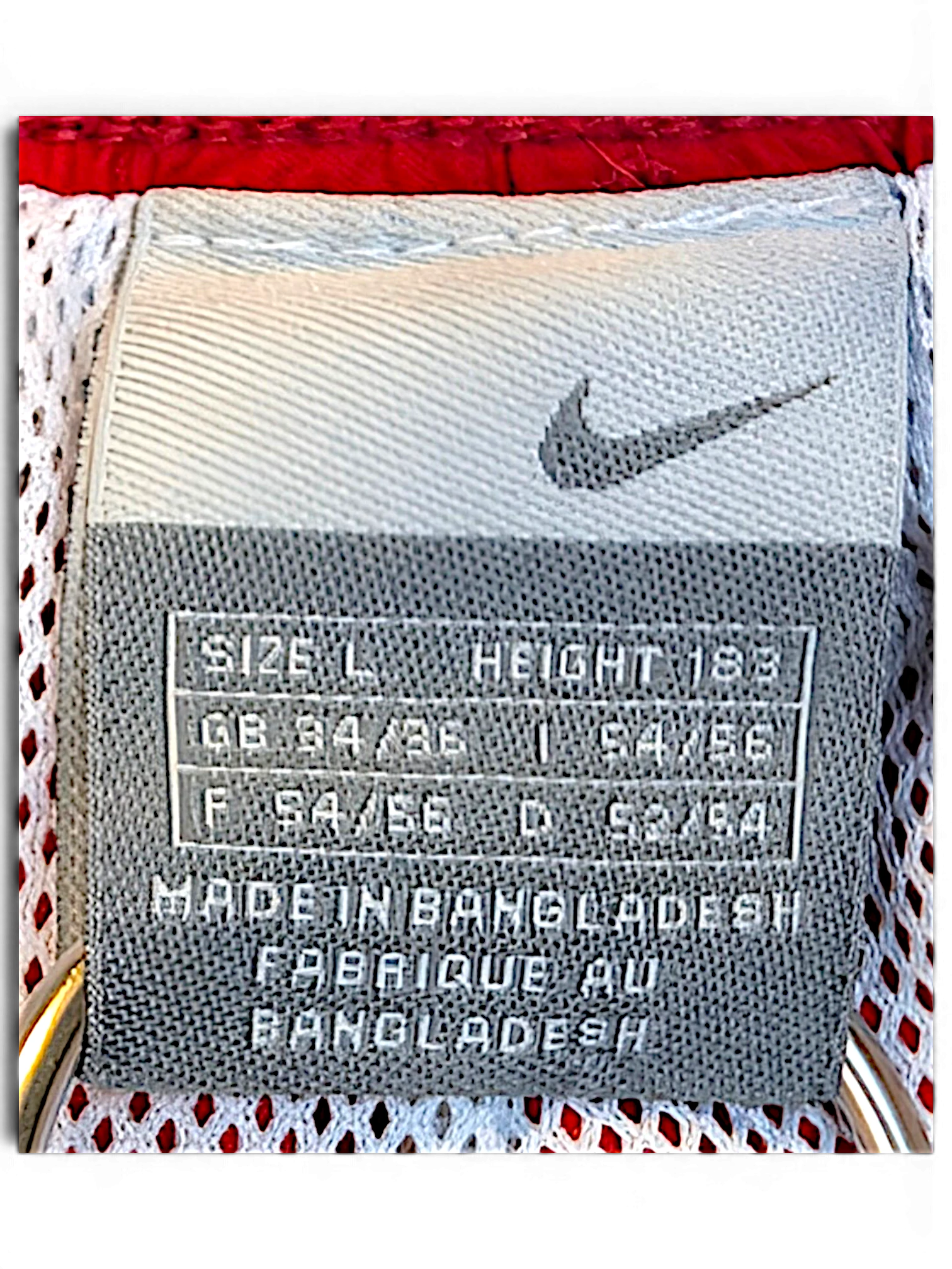 JAKE & IPI Nike track pants size L label showing Swoosh logo and manufacturing details