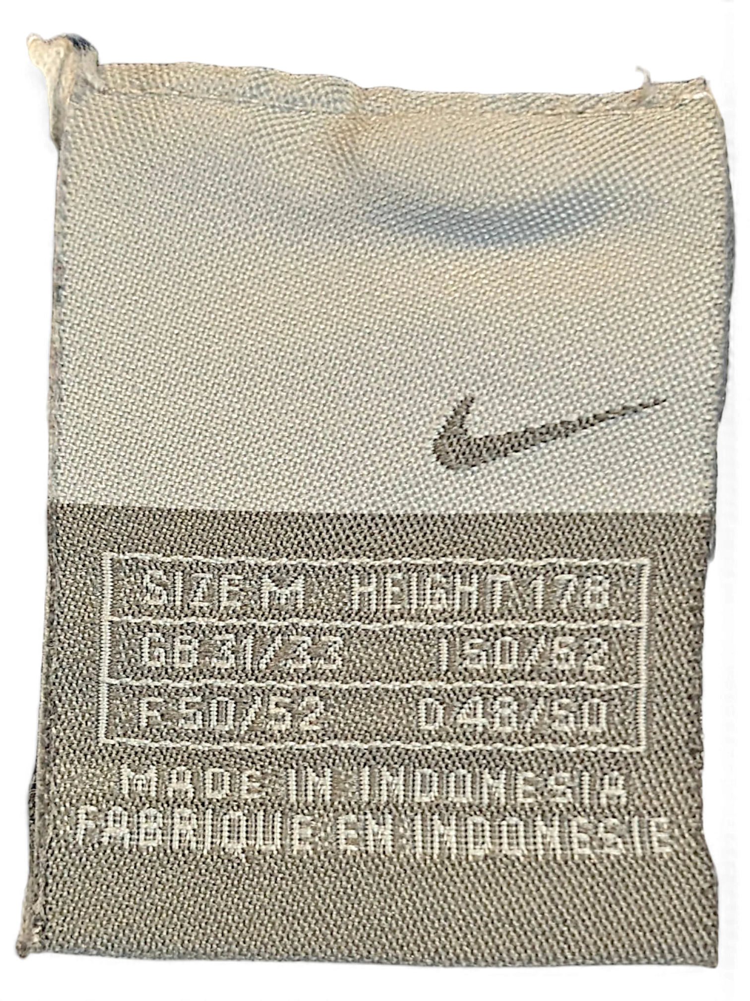 JAKE & IPI Nike navy windbreaker track pants size M clothing label with Swoosh logo and manufacturing details