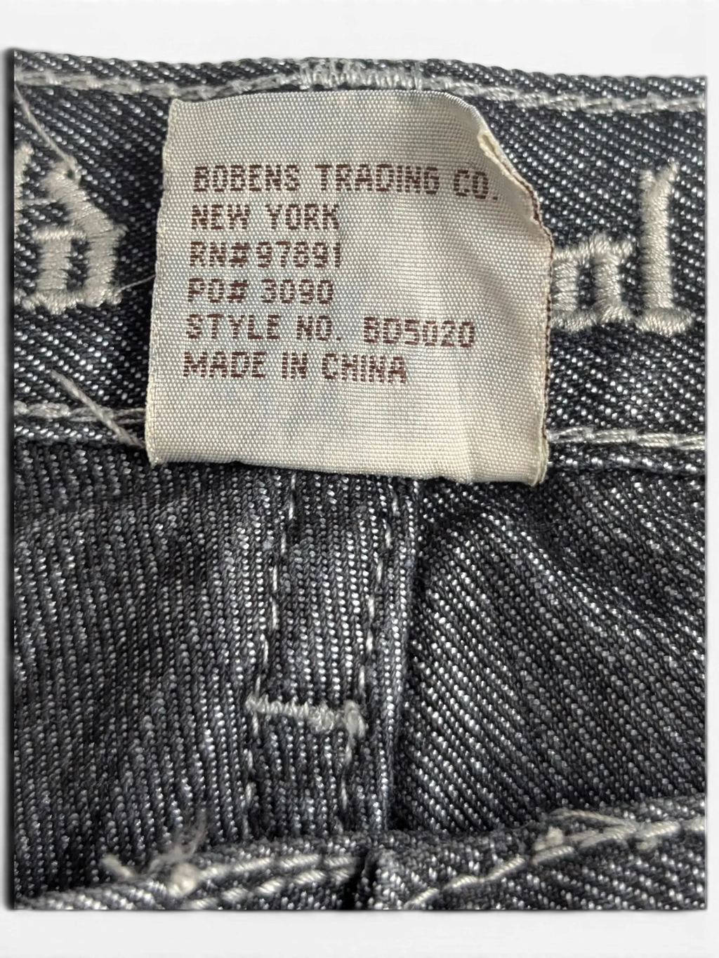 JAKE & IPI Old Skool jeans interior brand label with manufacturing details on dark grey denim fabric
